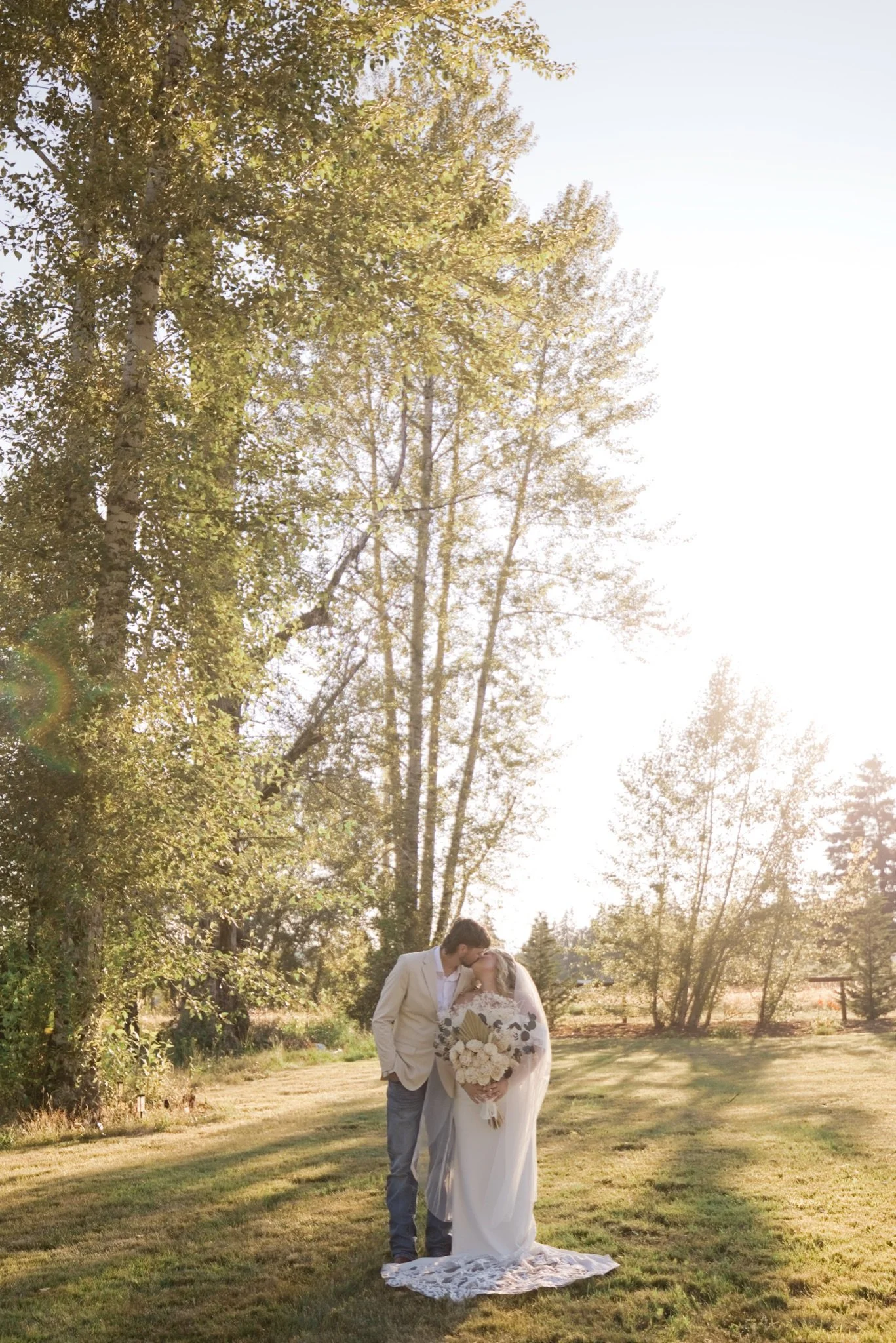 Sarah and Reed on the lawn beneath the tall cedars