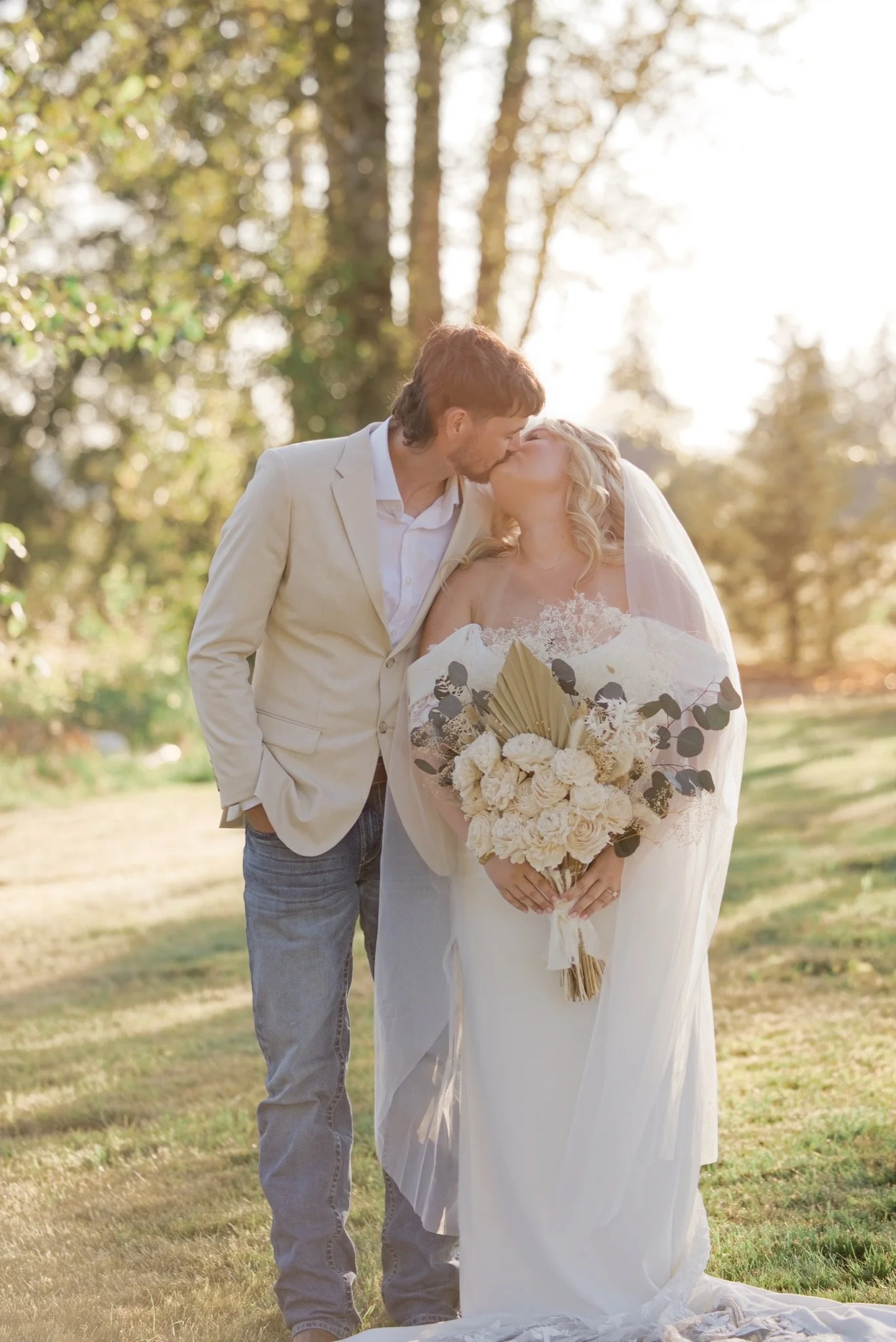 Sarah and Reed kissing with her bouquet between them
