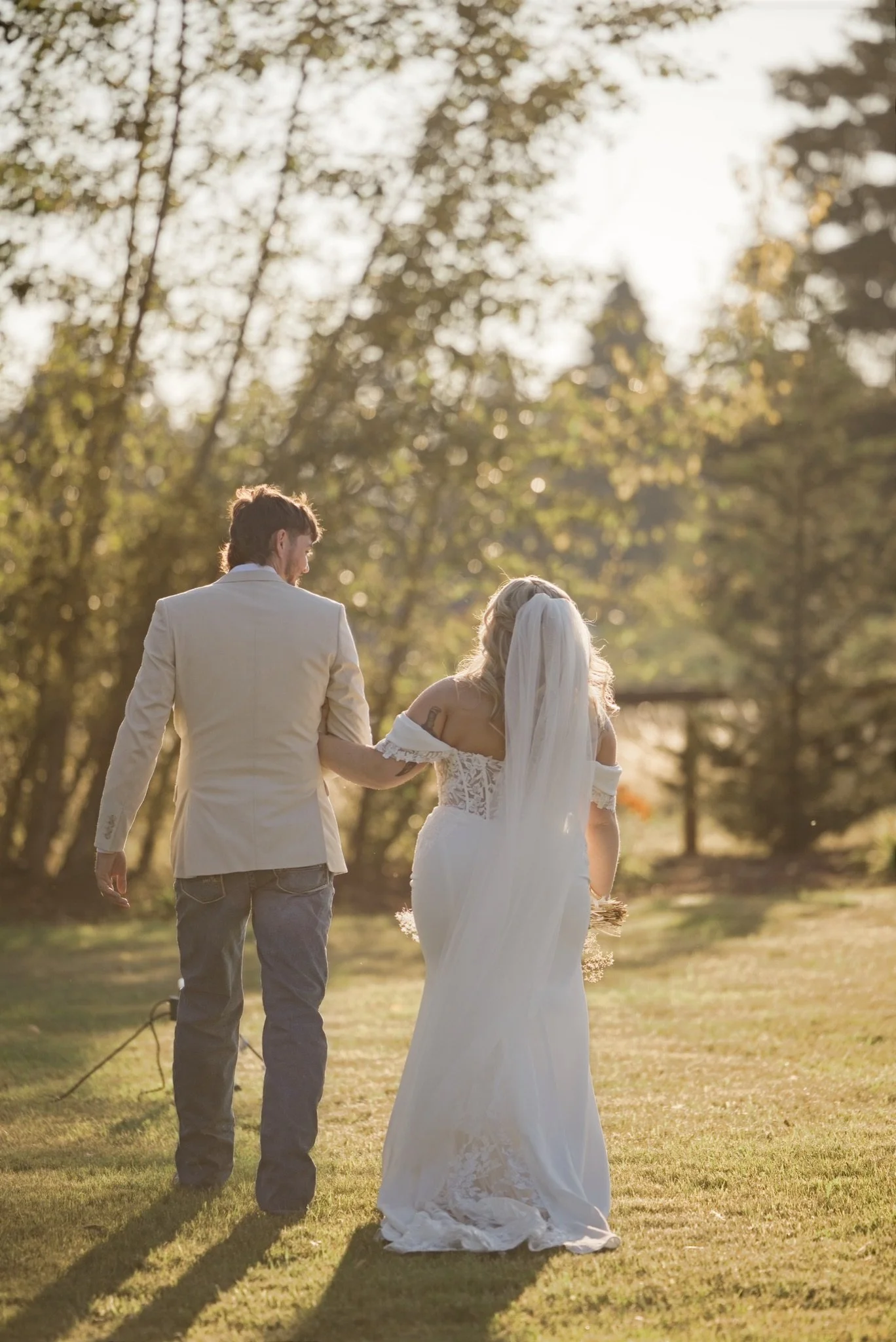 Reed and Sarah walking hand in hand across the lawn