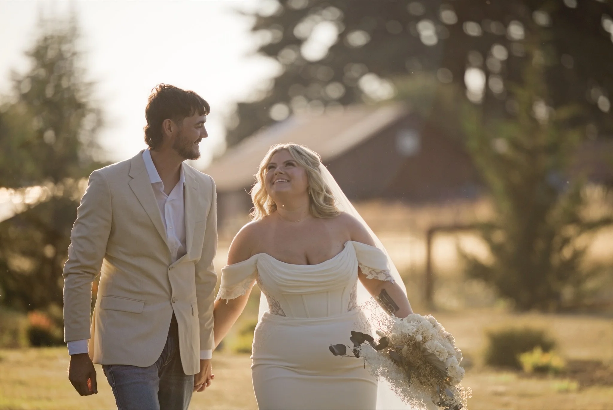 Sarah and Reed walking across the meadow in the golden light
