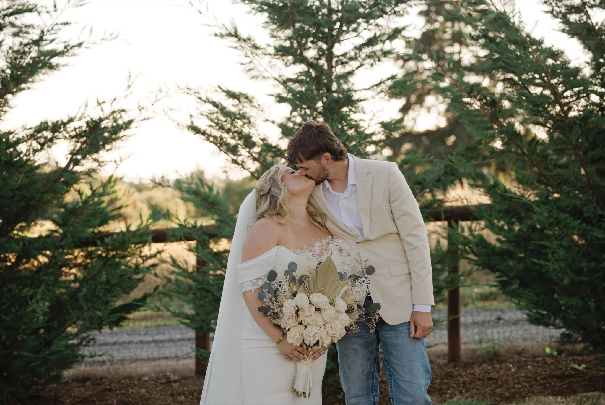 Reed kissing Sarah in front of the trees