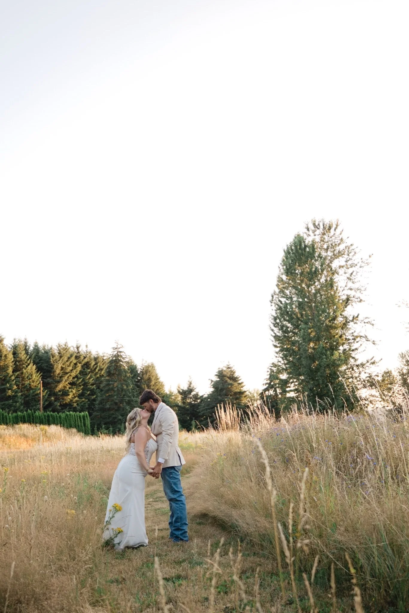 Sarah and Reed standing far out in the golden meadow
