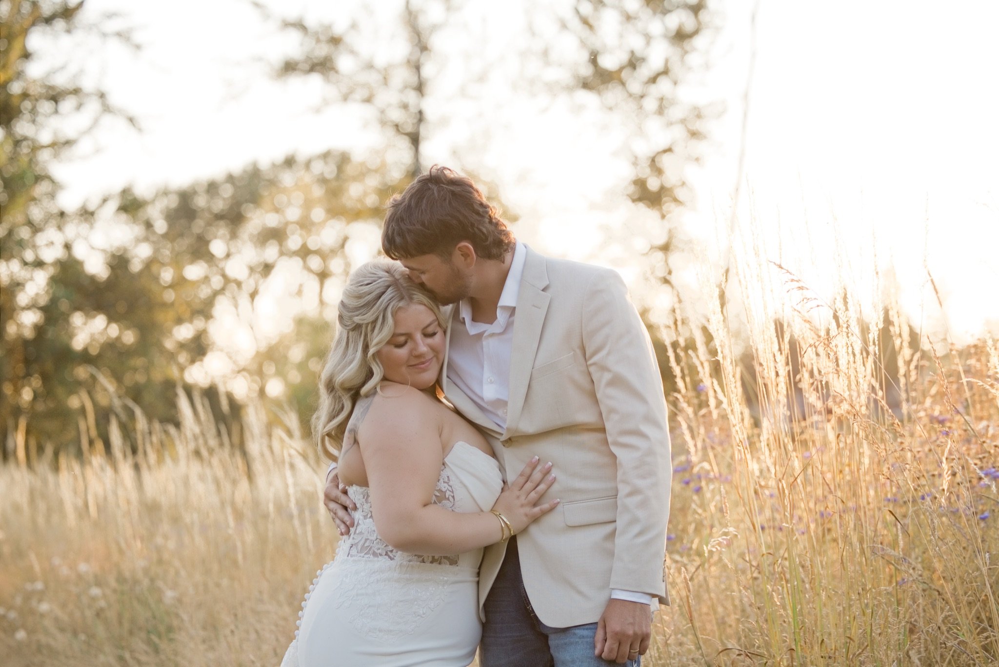 Reed kissing Sarah's forehead in the tall golden grass