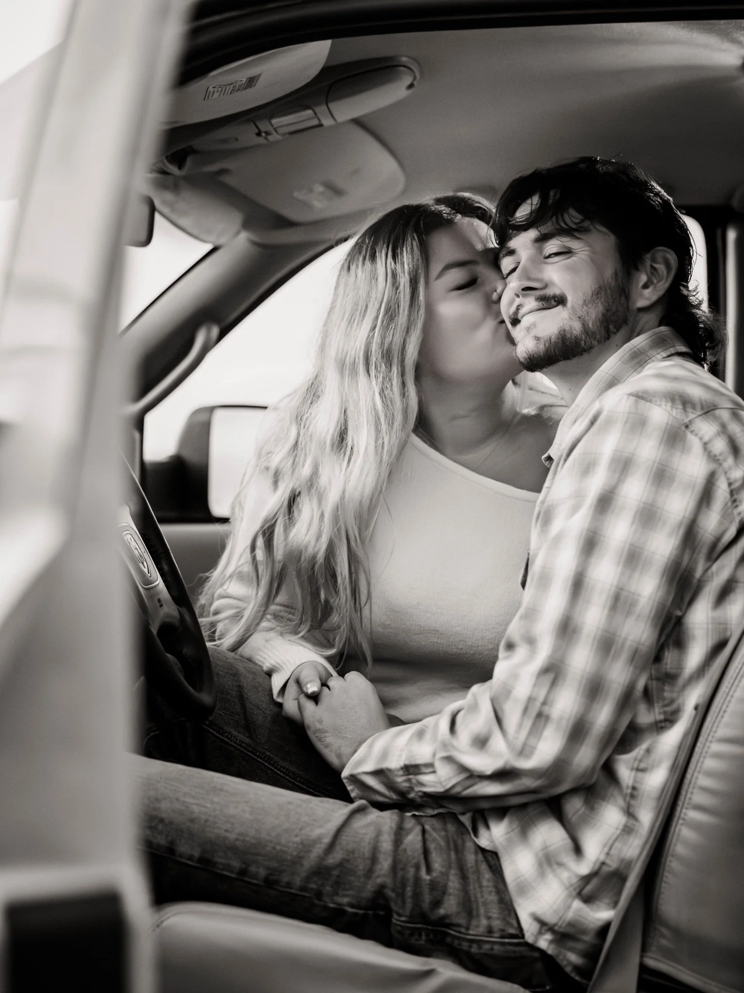 Sarah and Reed kissing in the car in black and white from their engagement session