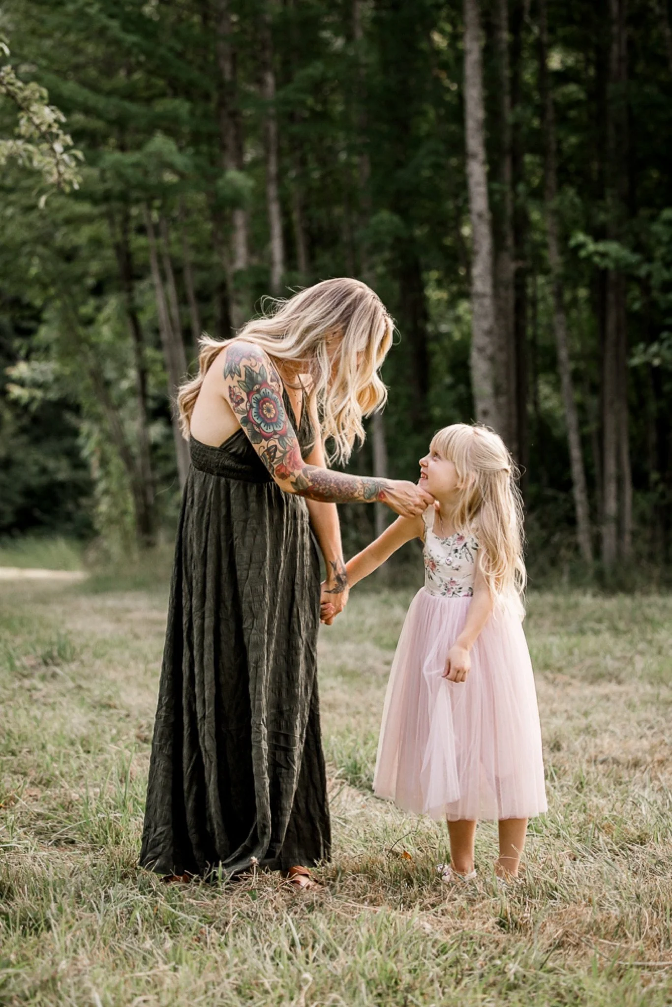 A mom in a long green dress holding hands with her daughter in pink, family session near Sandy Oregon