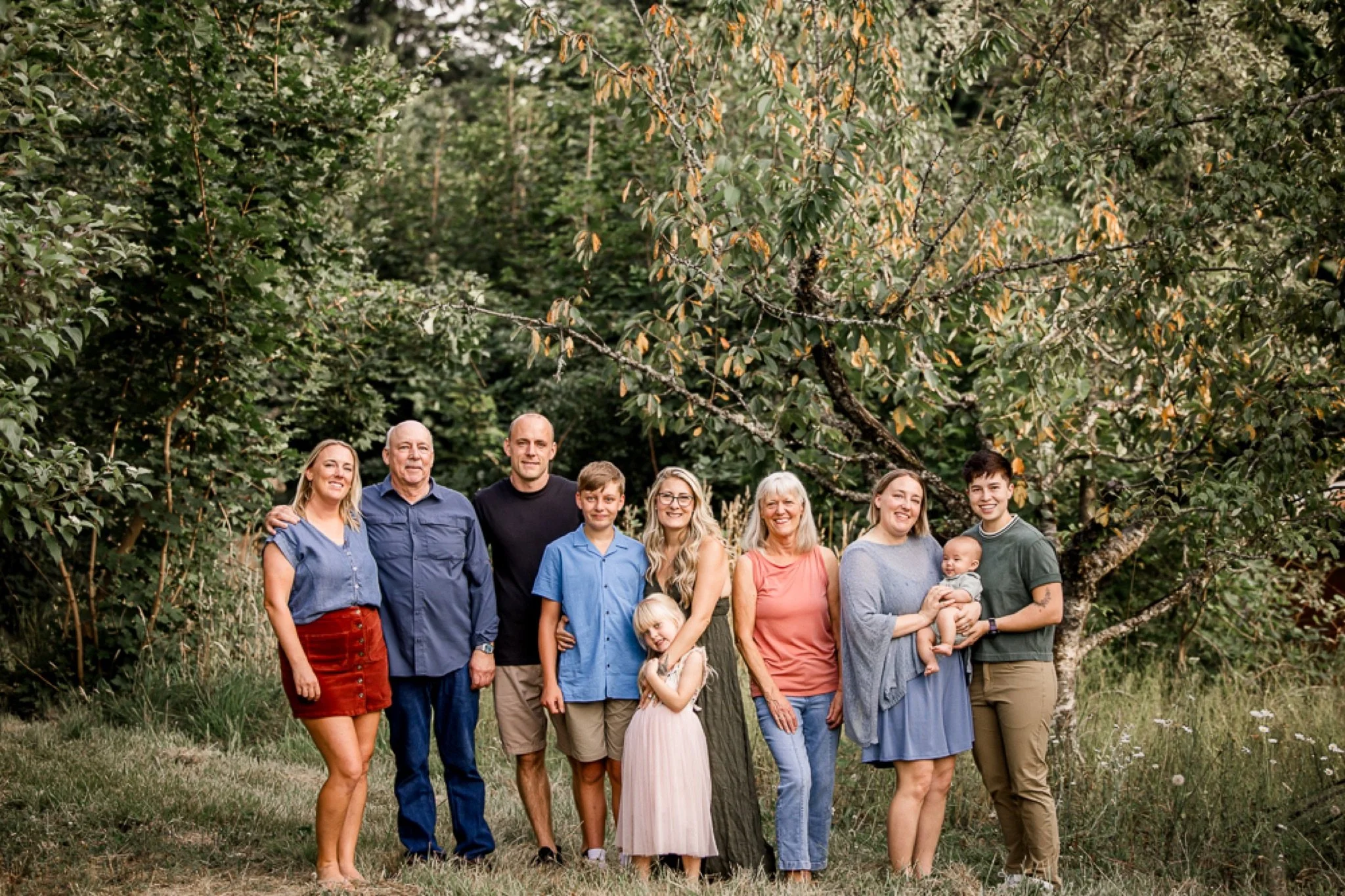 The whole family lined up at the edge of the trees at golden hour