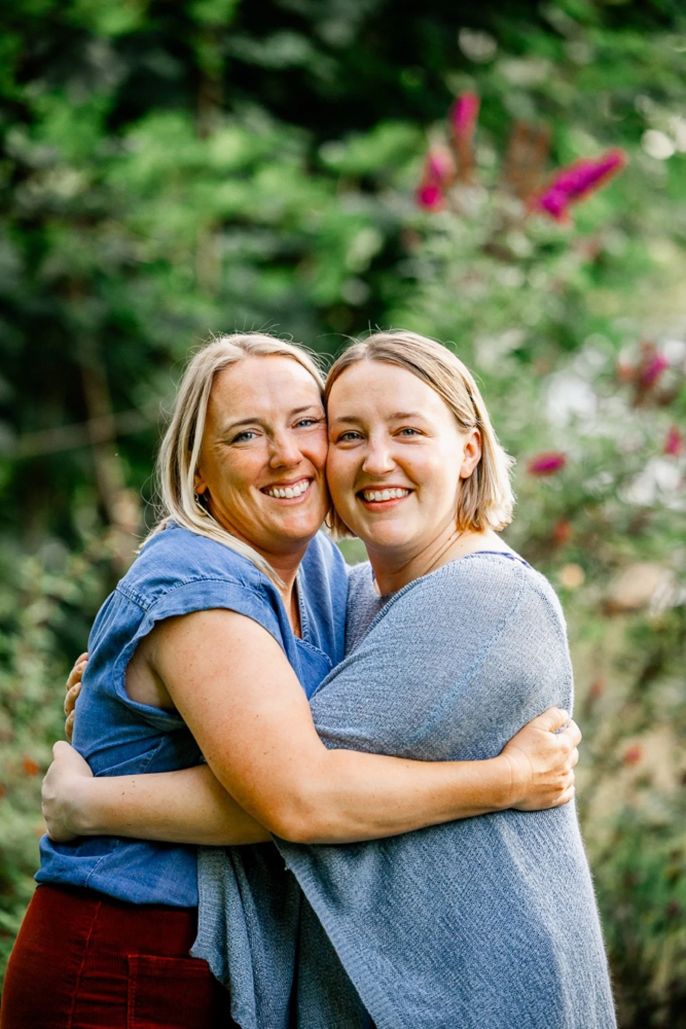 Two sisters hugging in front of the flowers