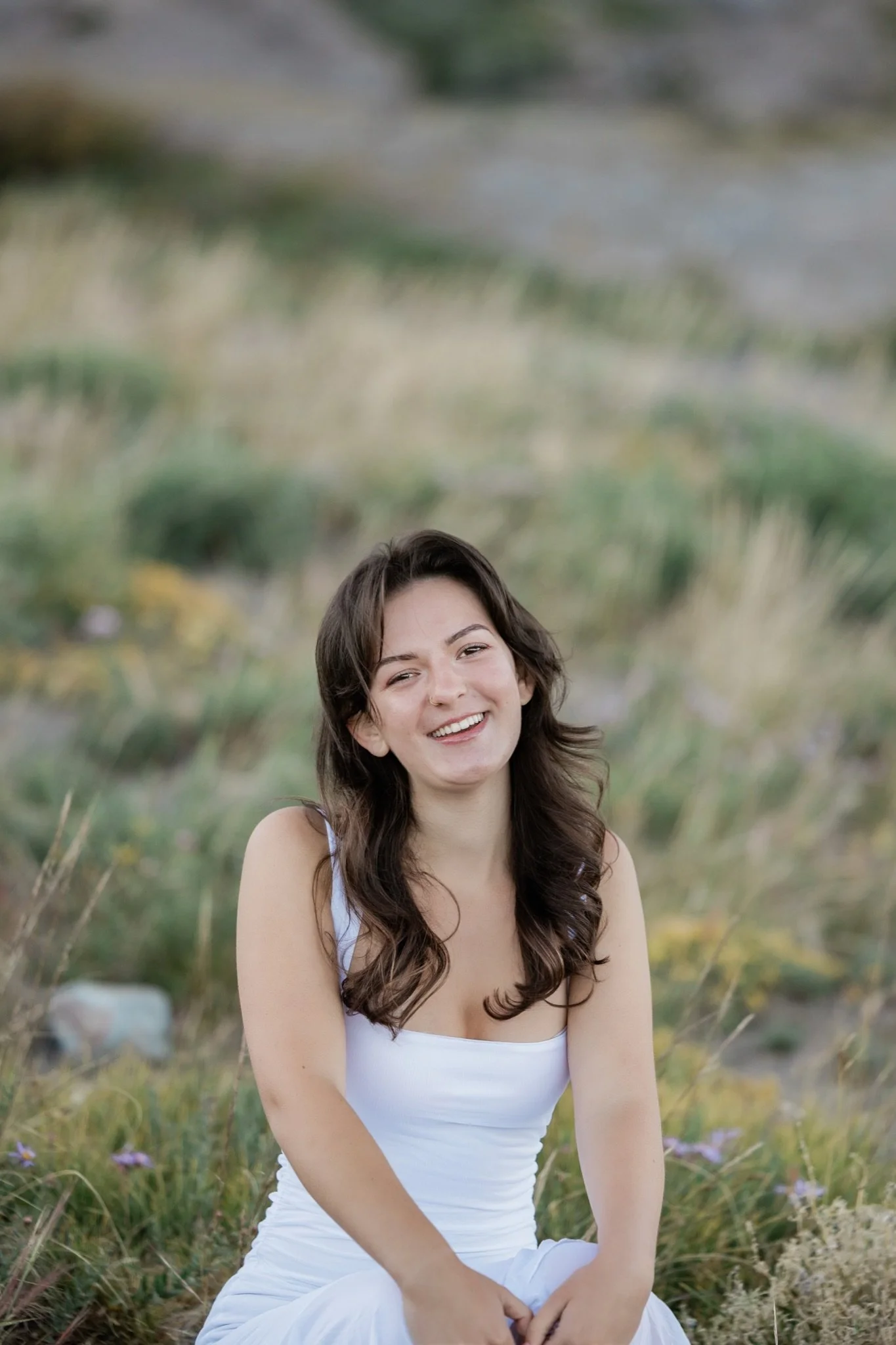 Hailey laughing in the golden grass on the mountain