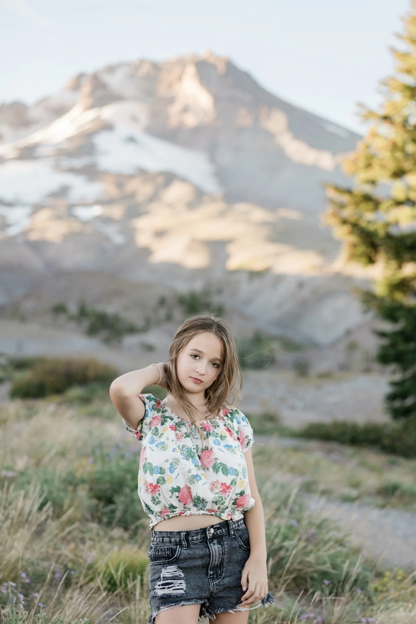 Hailey running her hand through her hair with Mt Hood behind her