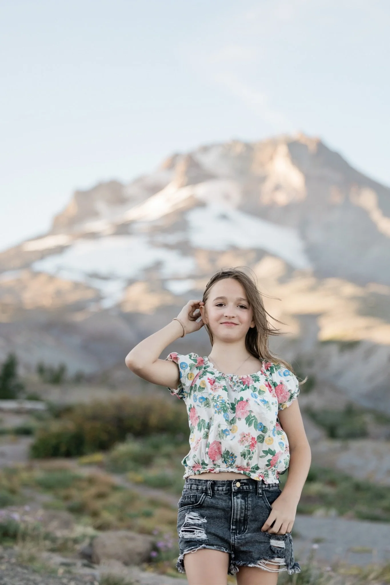 Hailey in a floral top smiling in front of the mountain