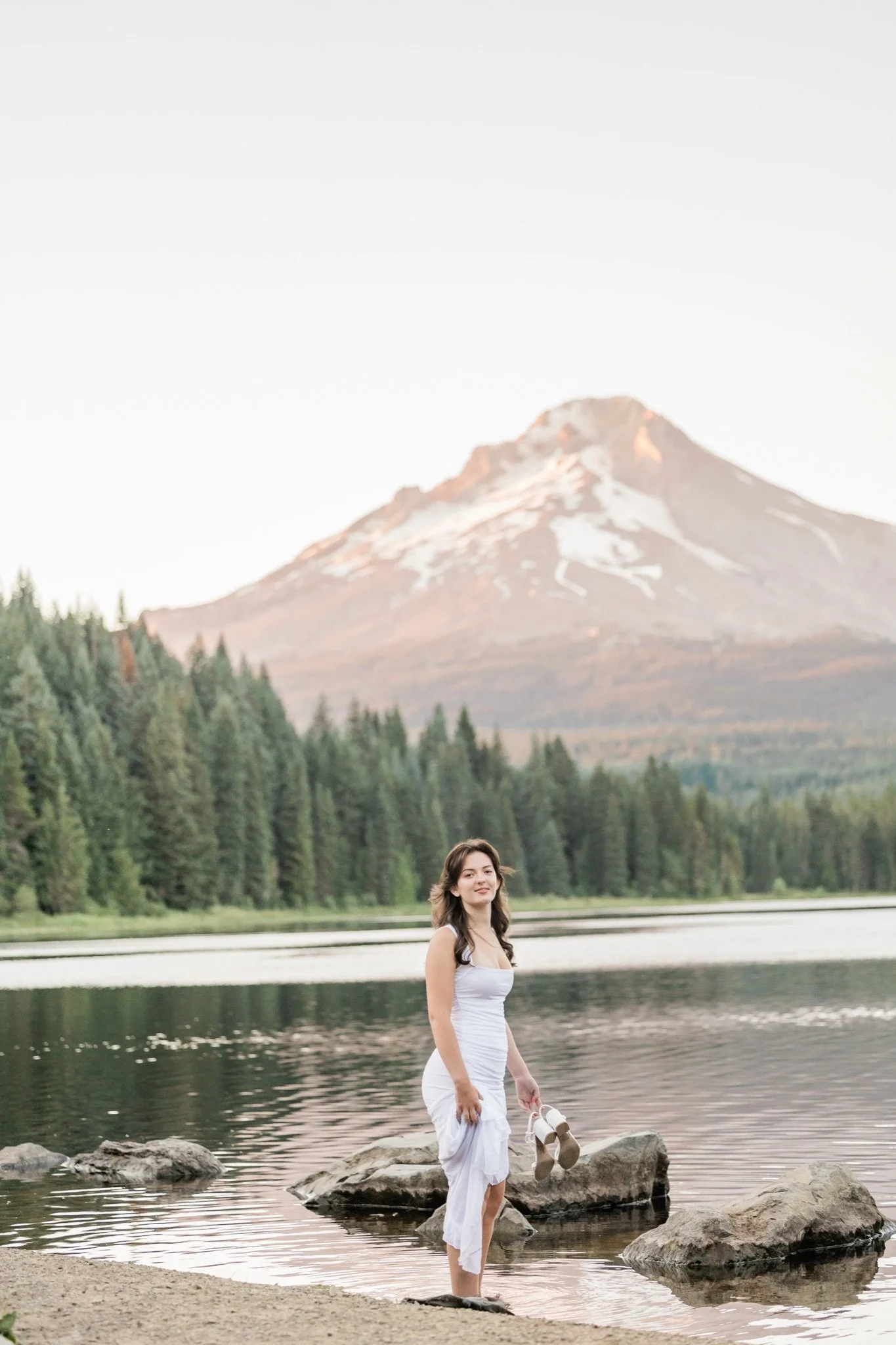 Hailey standing on the rocks at Trillium Lake with the mountain behind her