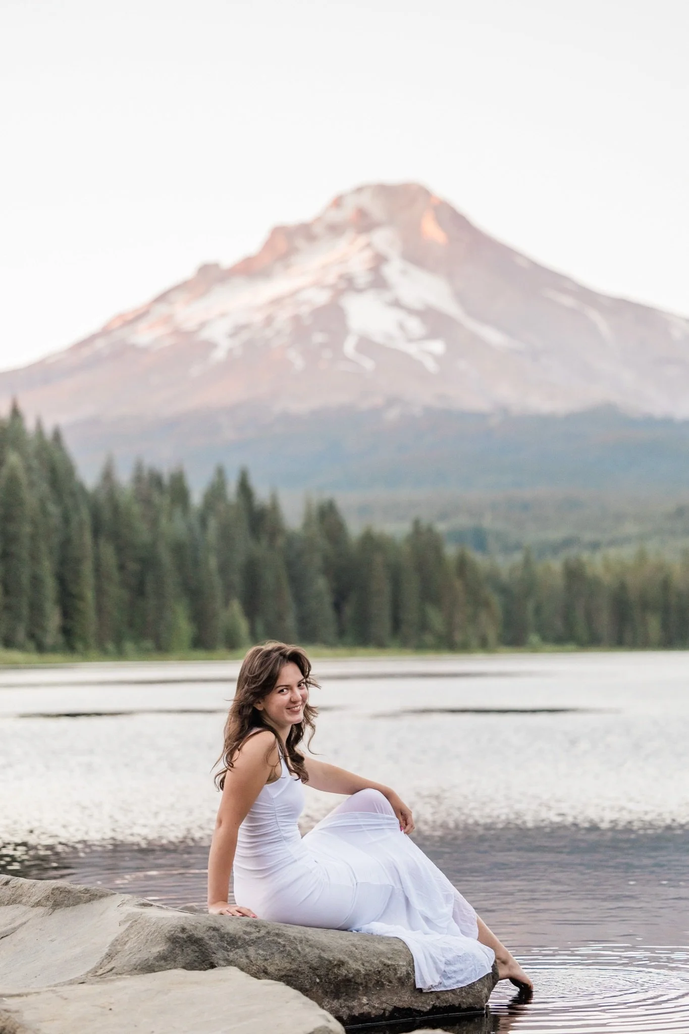 Hailey sitting at the edge of Trillium Lake in her white dress