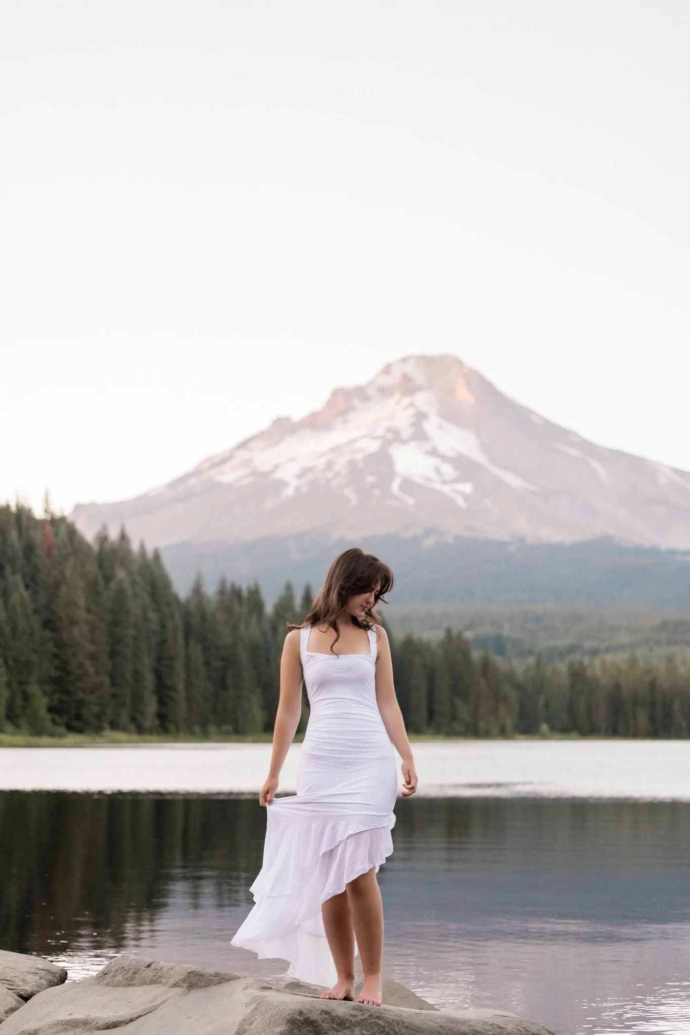 Hailey standing at Trillium Lake with the mountain reflected in the water