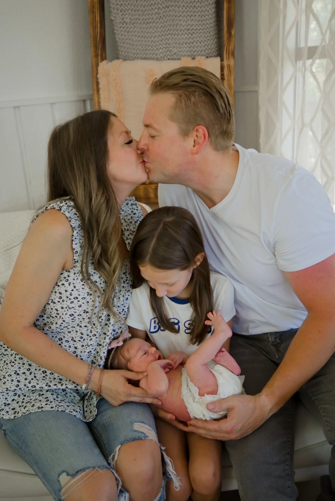 Mom and dad kissing with their daughters, Stevie and her big sister, in the studio