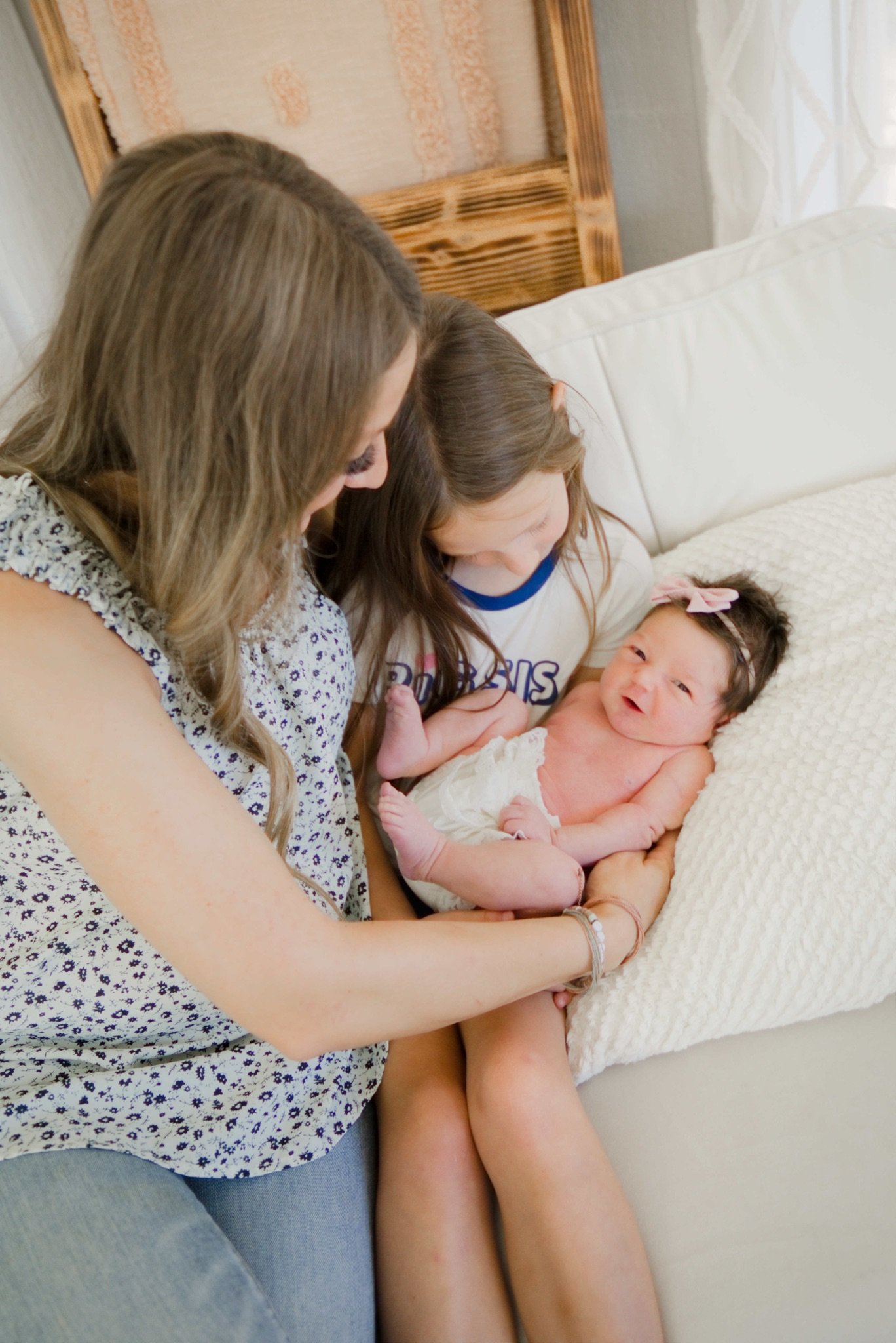 Mom with her two daughters snuggled on the couch in the studio