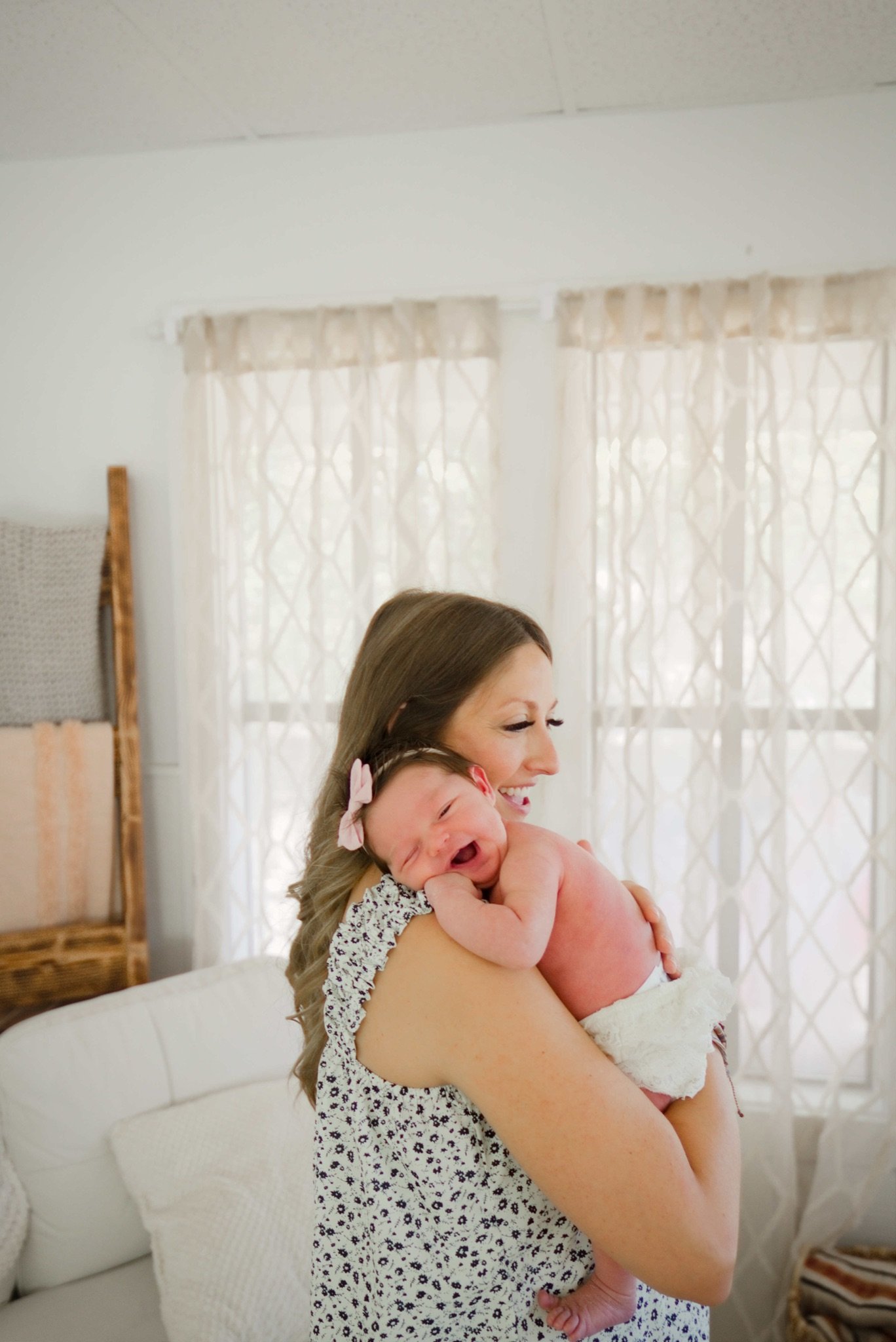 Mom holding Stevie against her shoulder by the window