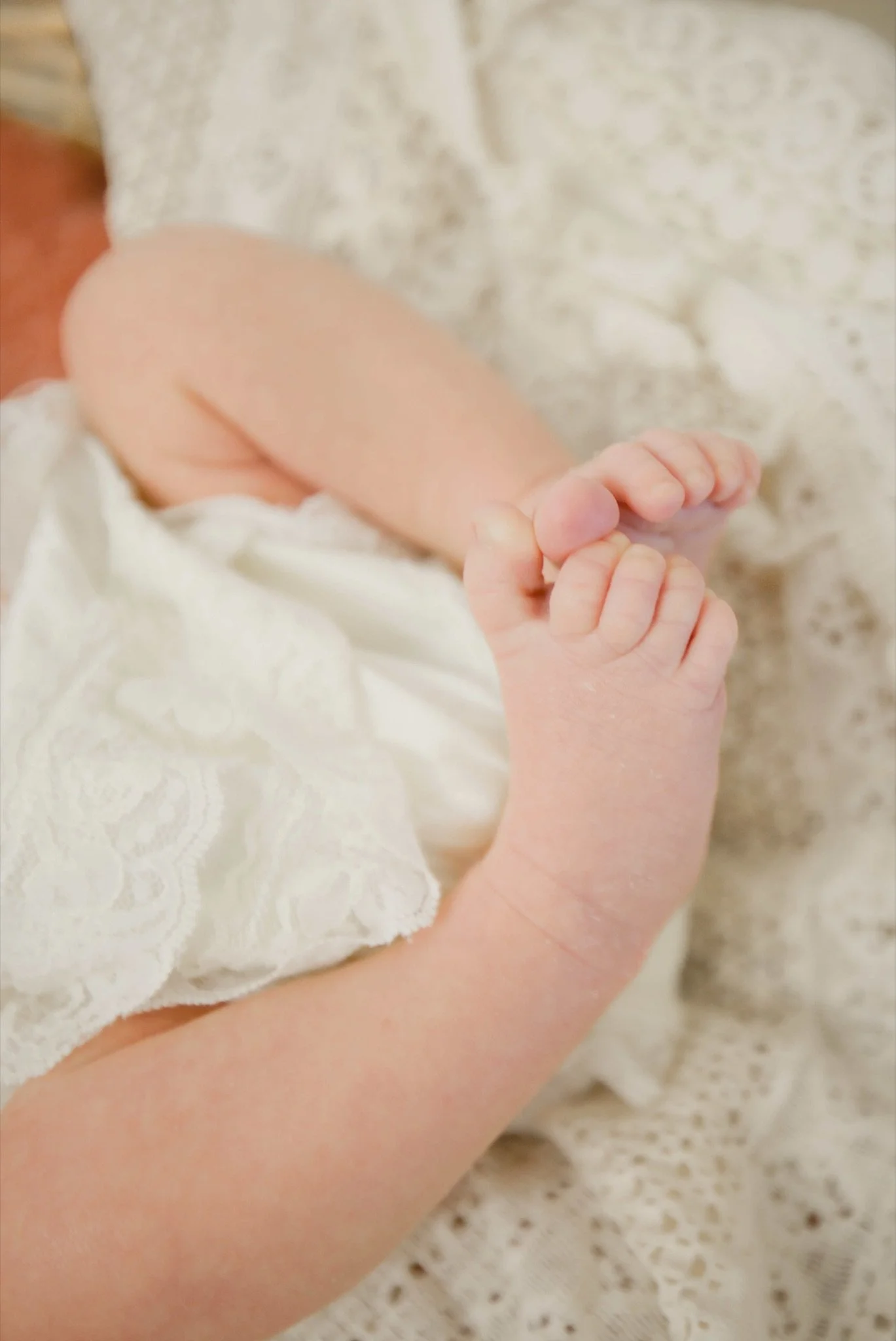 Newborn Stevie's tiny feet on a white blanket