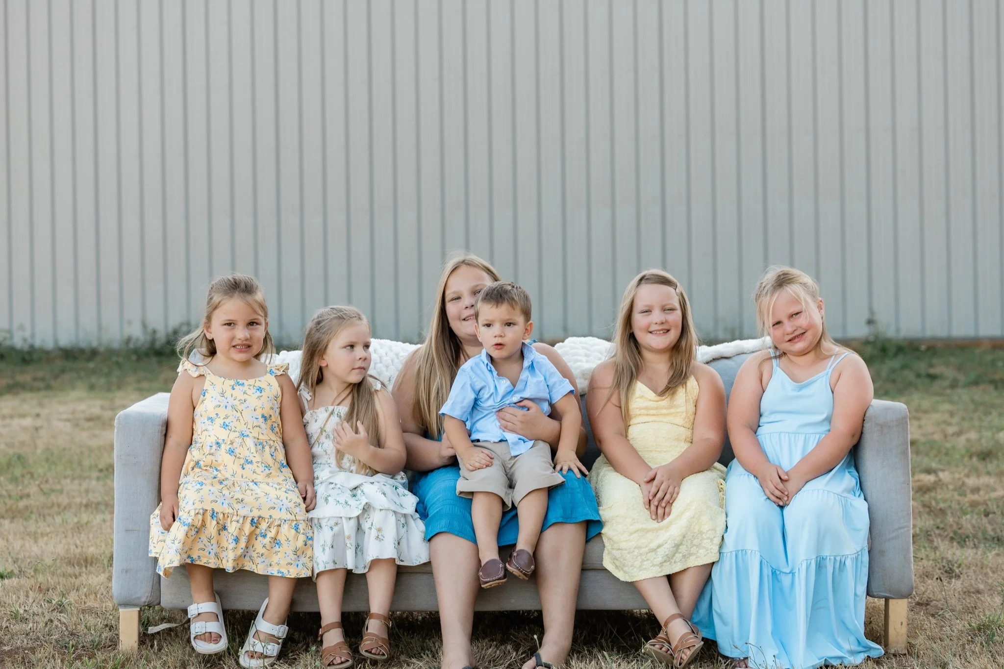 Grandma with two little girls in yellow and blue on the couch