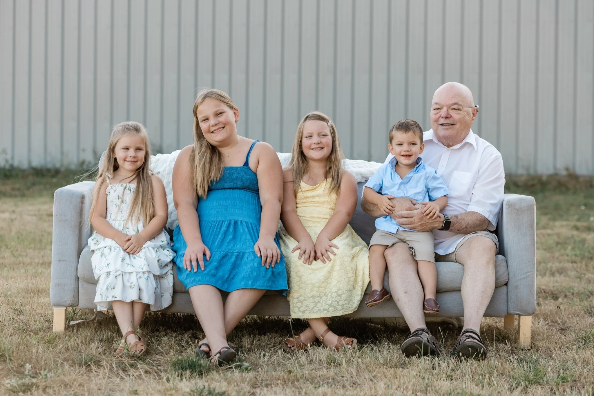 A family with the grandparents on the couch in the evening light