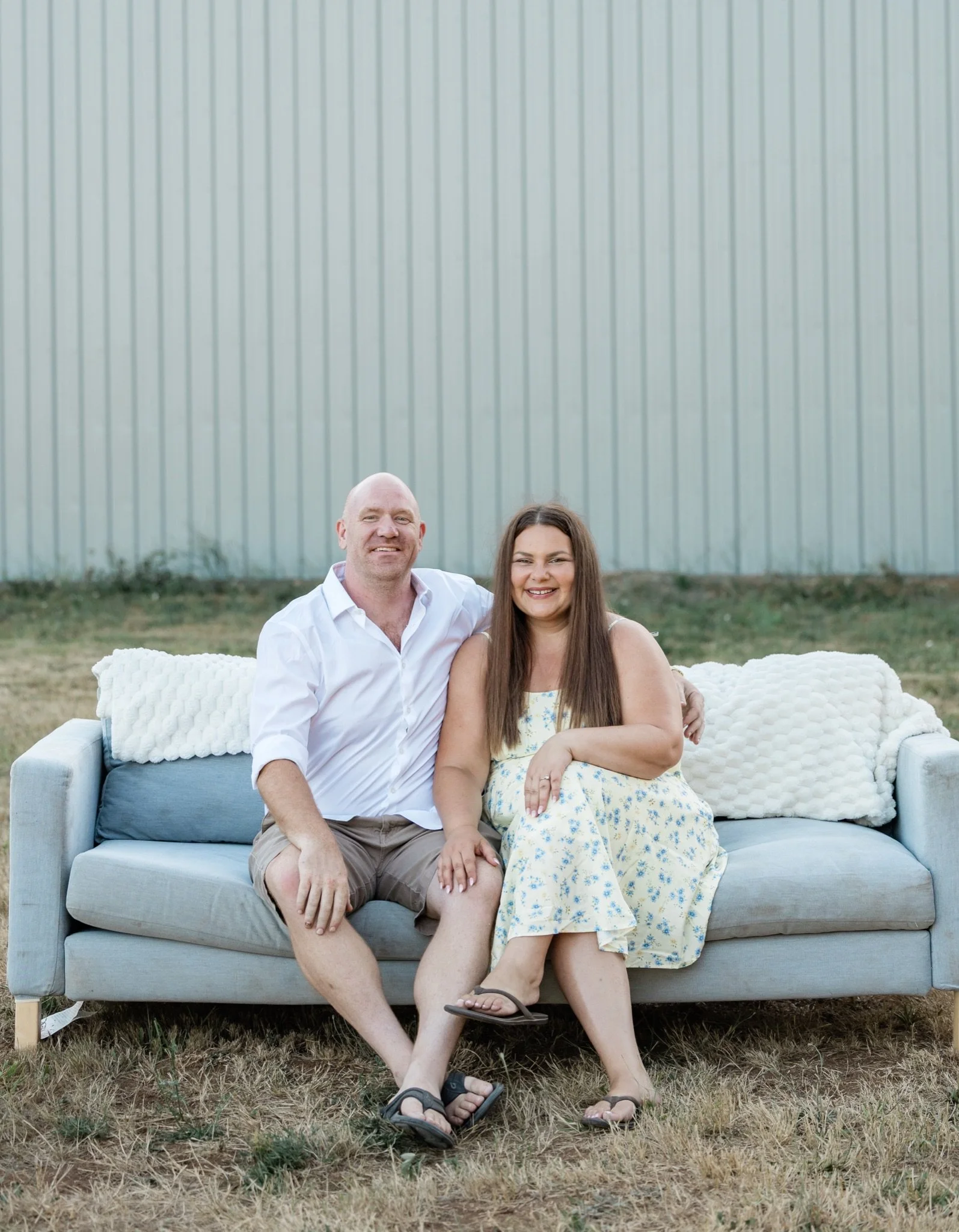 Grandparents seated together on the couch in the evening light