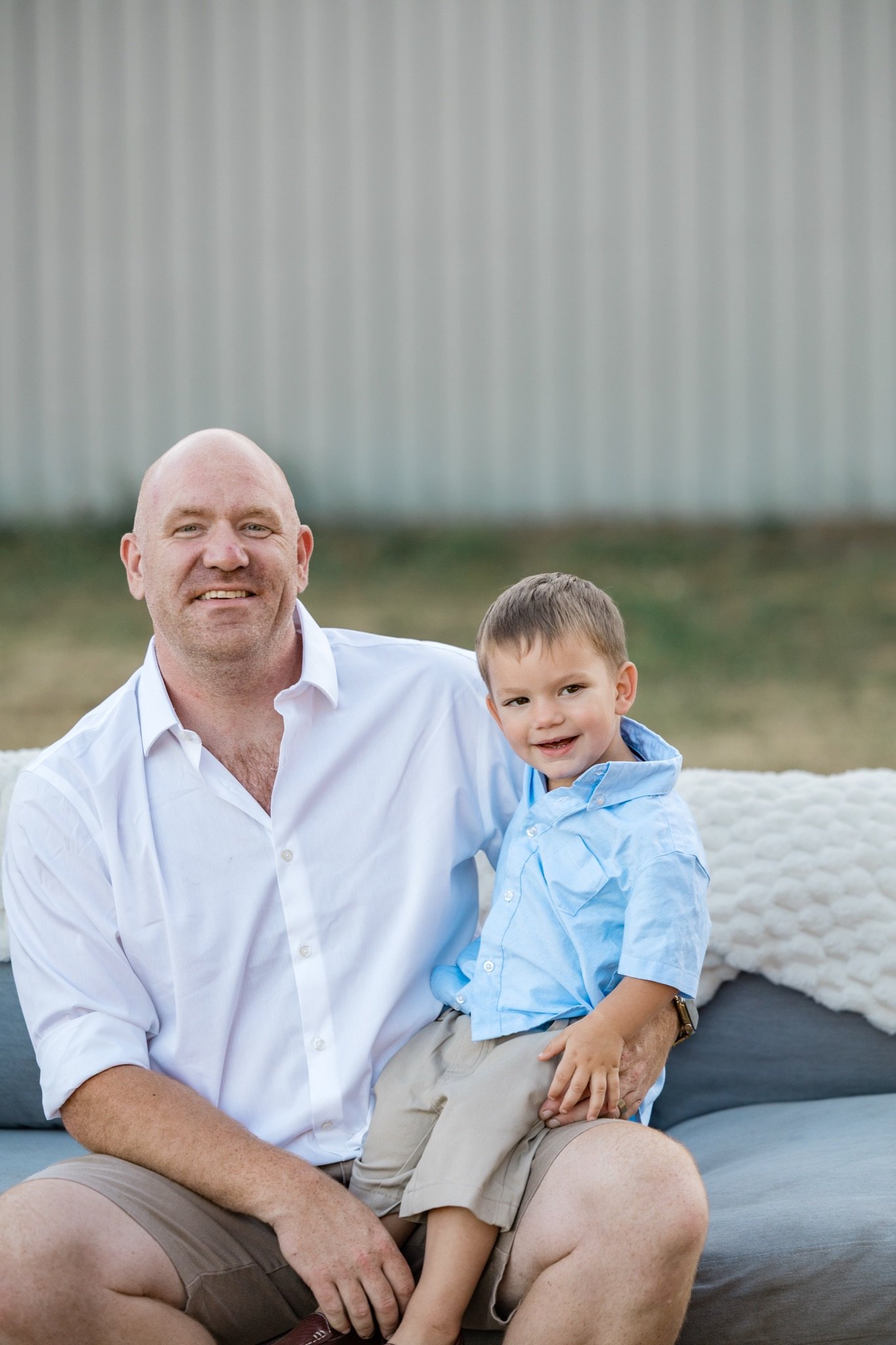 Dad holding his son in a blue shirt on his lap