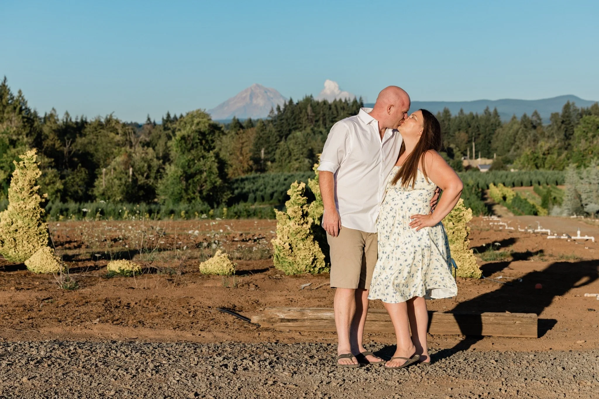 Mom and dad kissing in the field with Mt. Hood on the horizon, Sandy Oregon family photographer