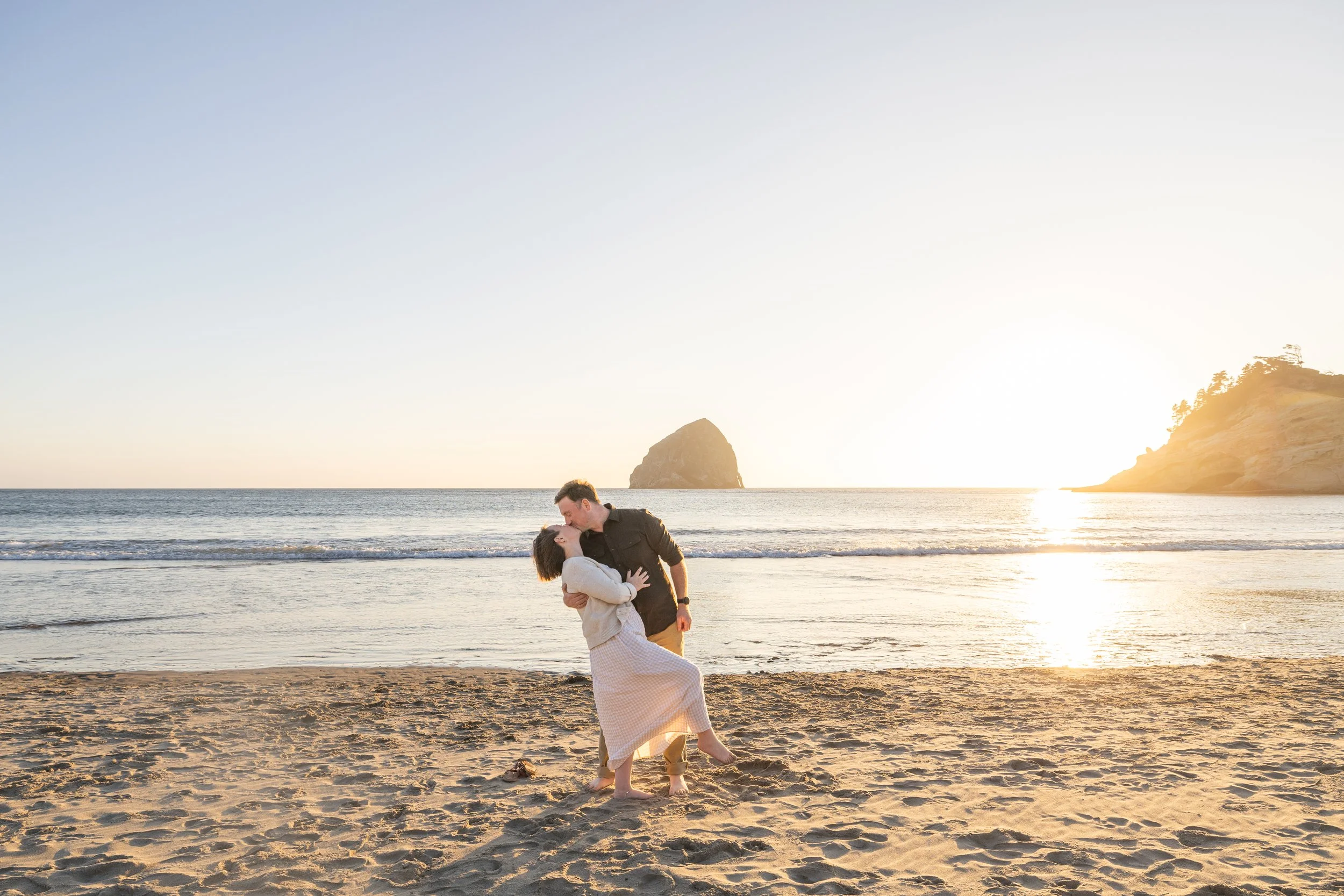 Dad dips mom for a kiss on the wet sand as the sun sets behind Cape Kiwanda, Cape Kiwanda family photographer