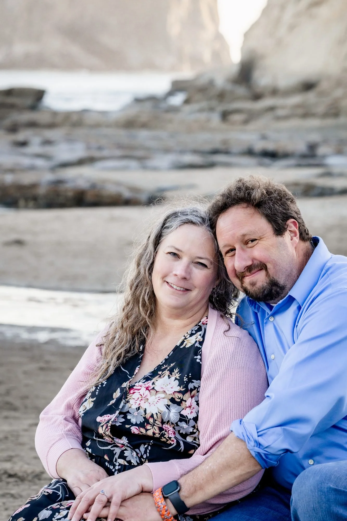 Tori and Jamie smiling together on the beach at Cape Kiwanda in Pacific City