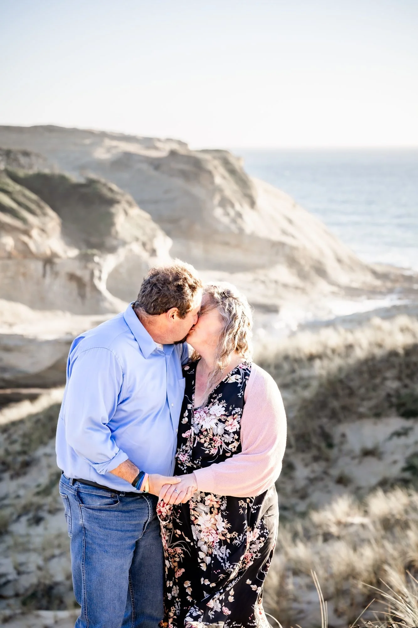Tori and Jamie kissing in the dune grass at Cape Kiwanda