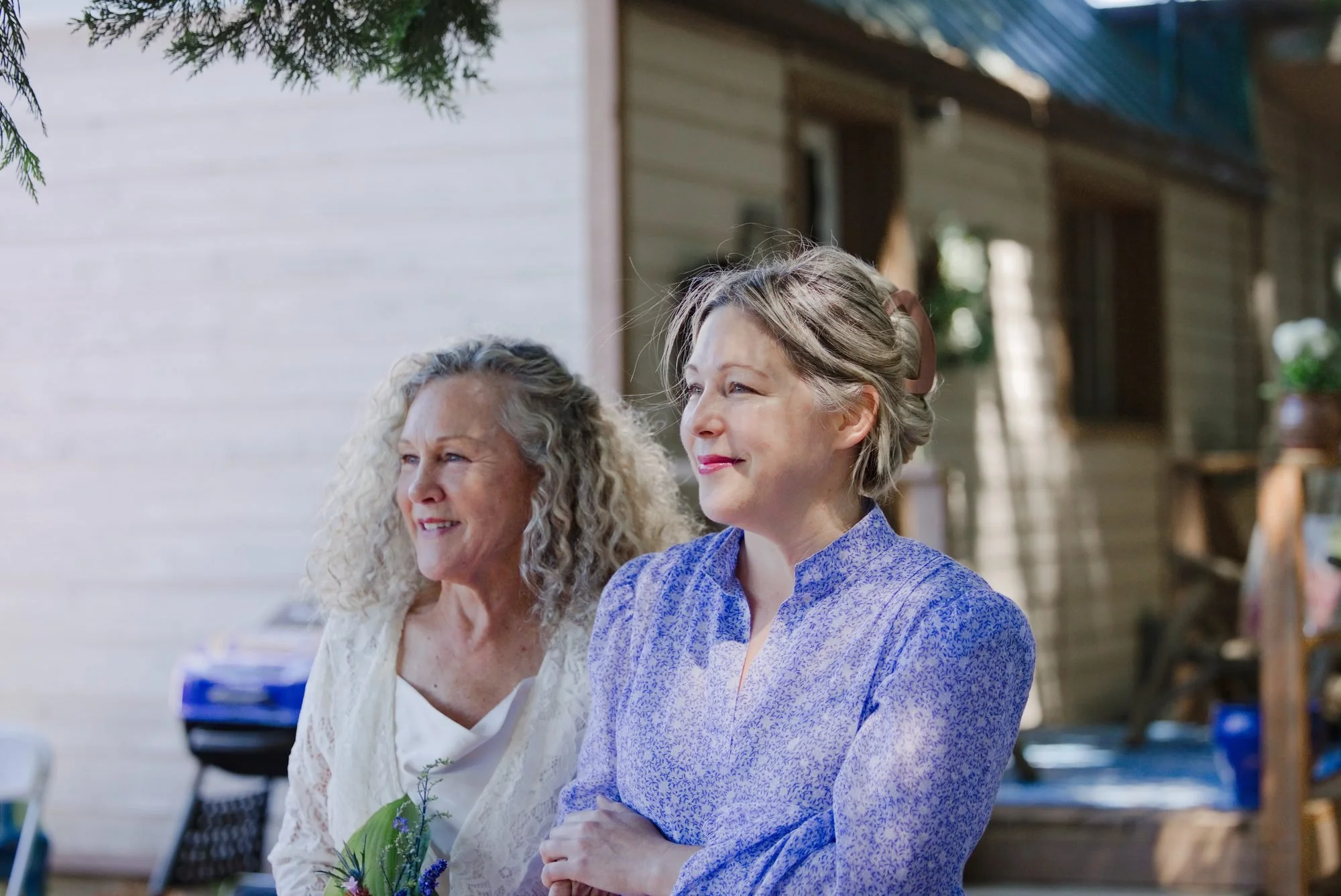 Trudy and her daughter smiling together during the backyard wedding ceremony