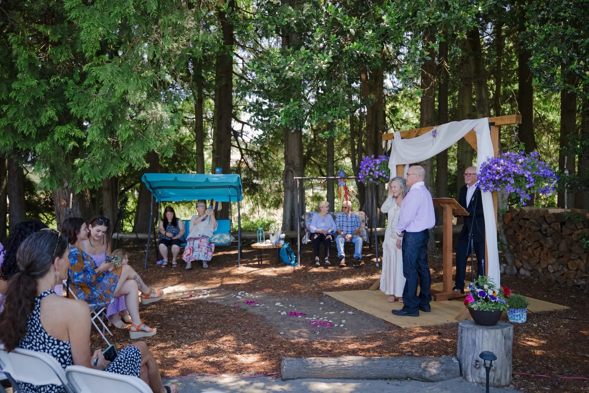 Guests watching the ceremony under the tall trees in rural Troutdale