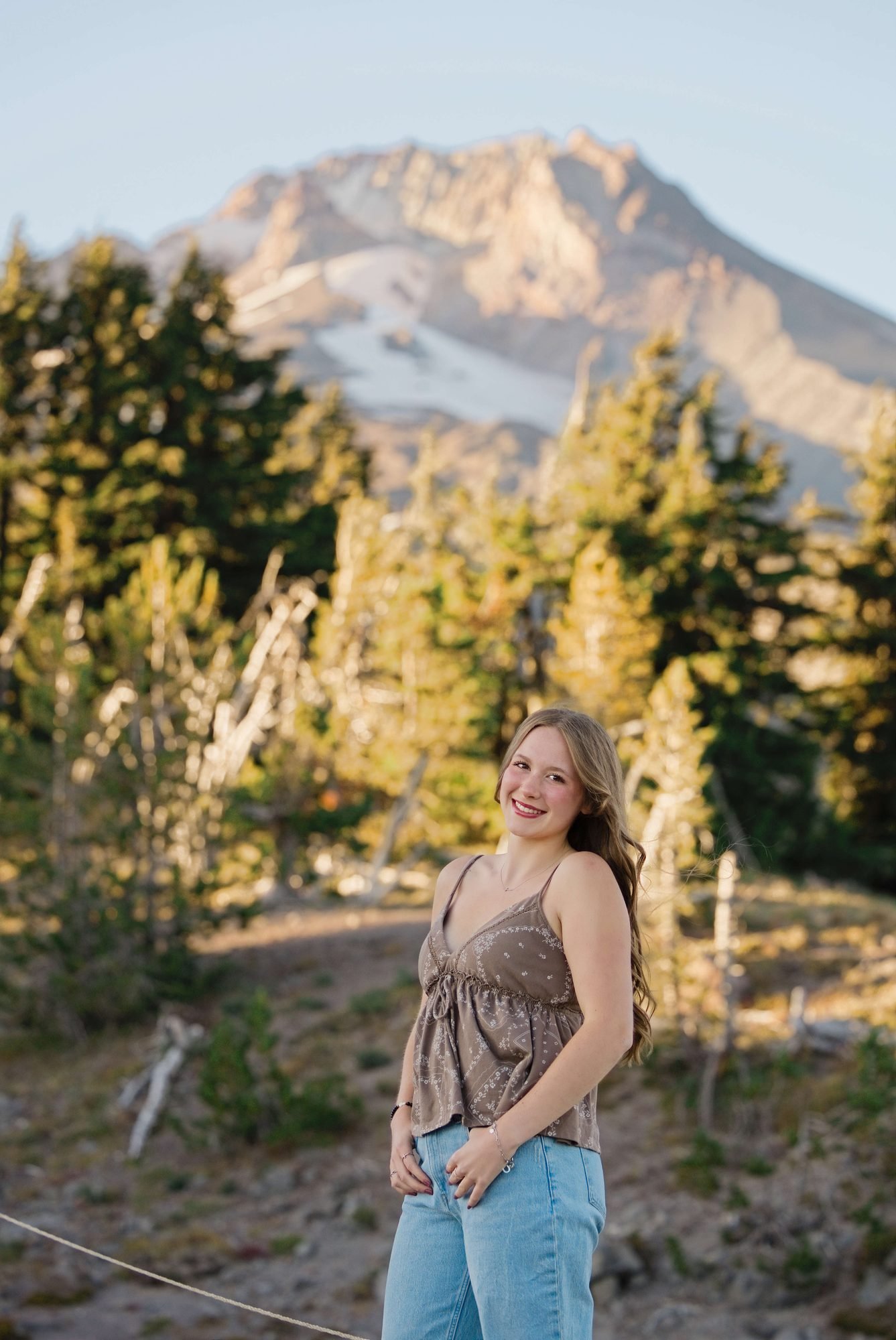 A senior laughing on the trail with the summit of Mt. Hood in the background