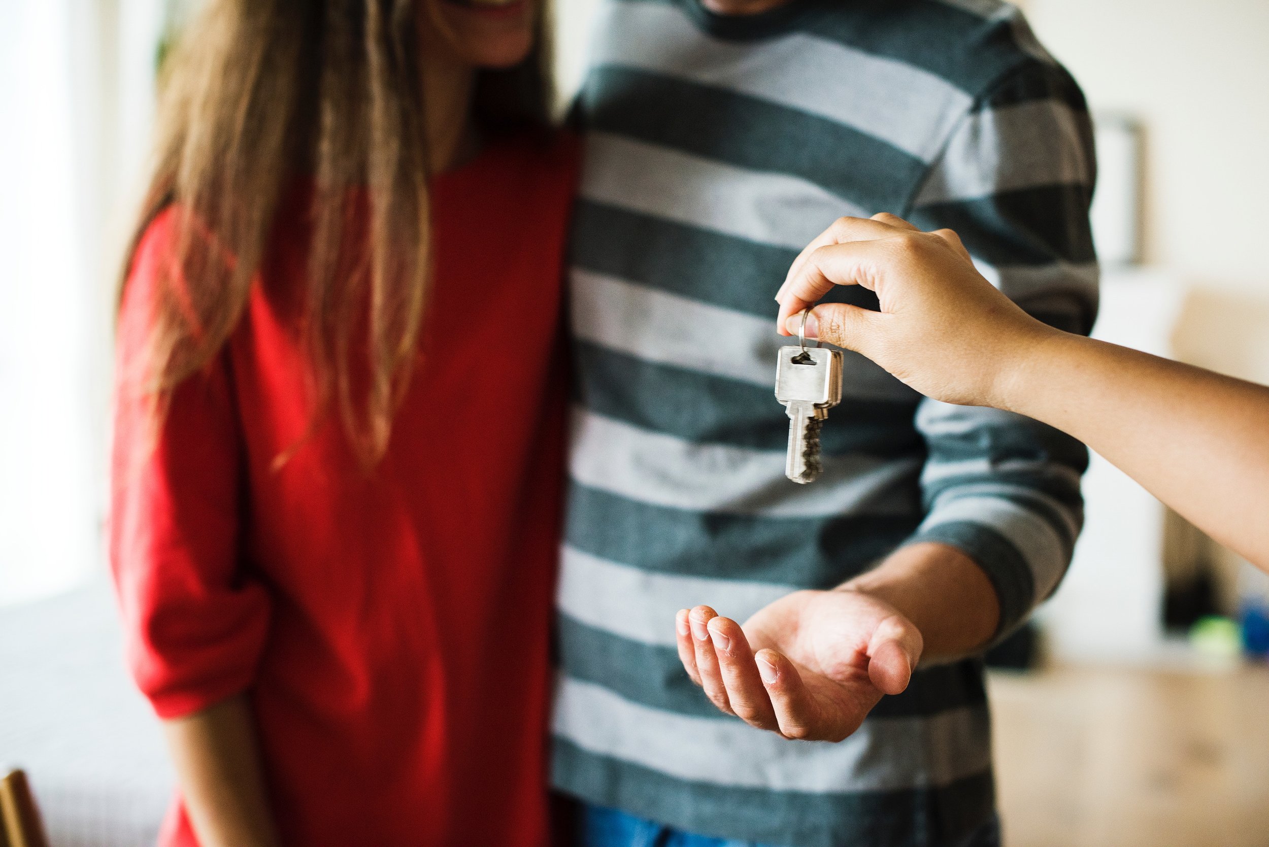 realtor handing house keys to couple