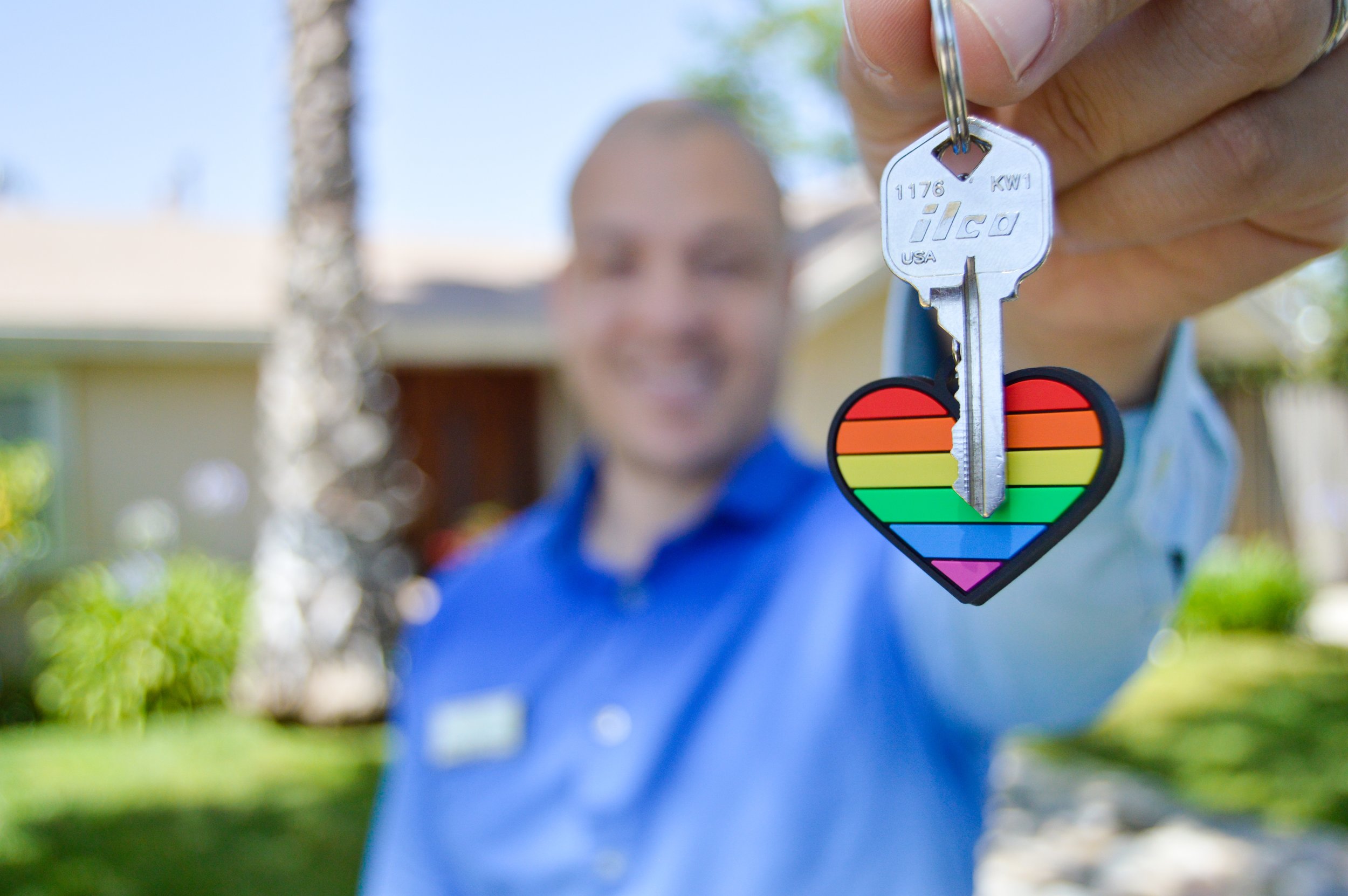 man holding house keys with pride keychain