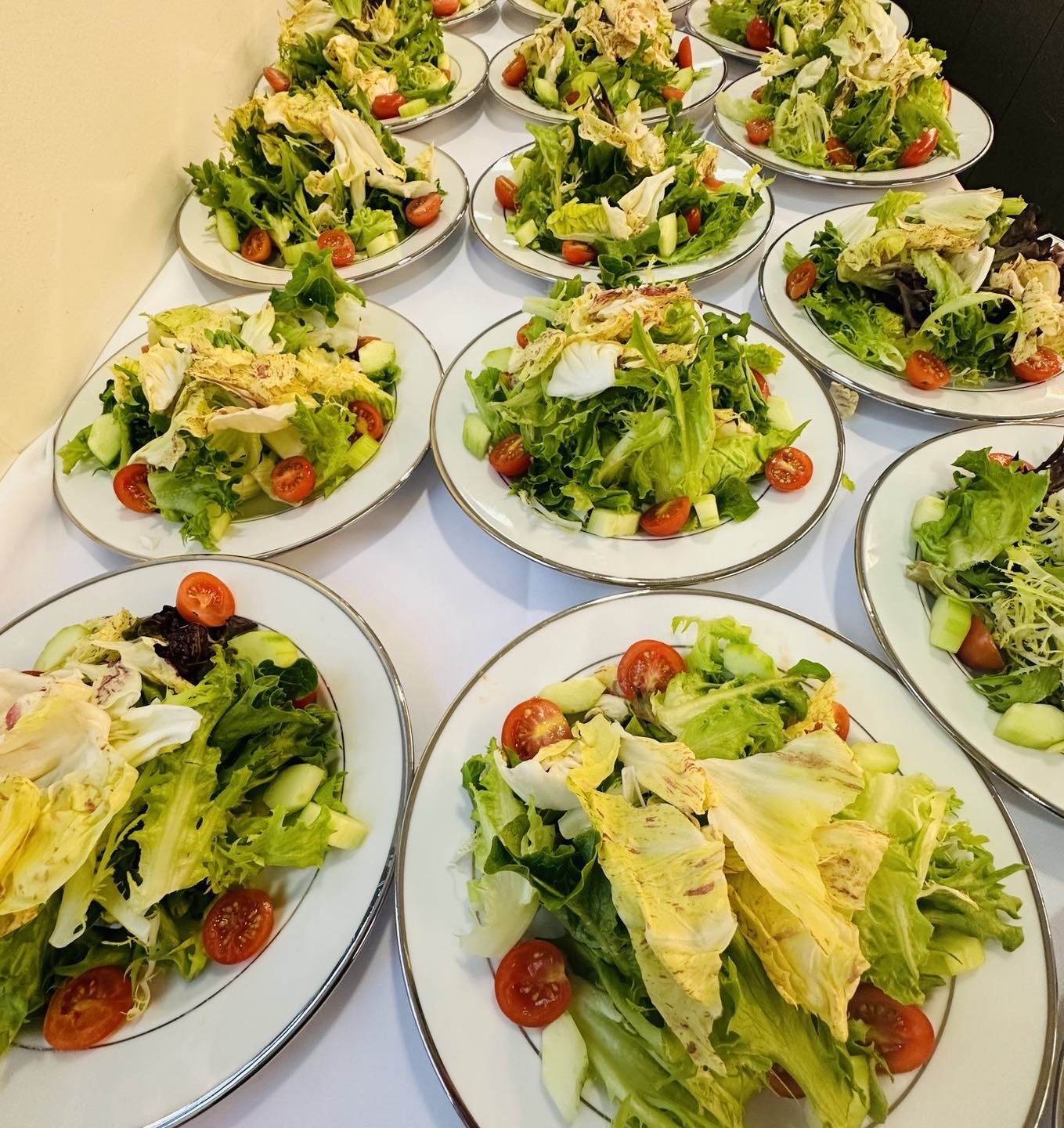Spring salads waiting to be served at a seated dinner.  Castelfranco adds a nice contrast to the mixed greens.