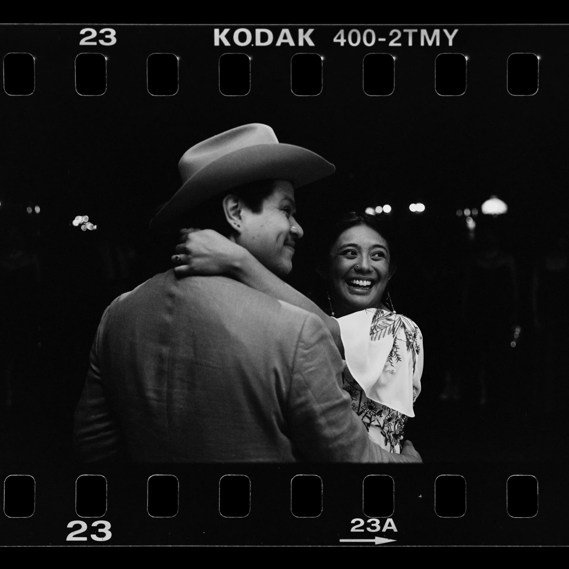 Black and white 35mm photo with visible sprocket holes of a man and a woman who just got married