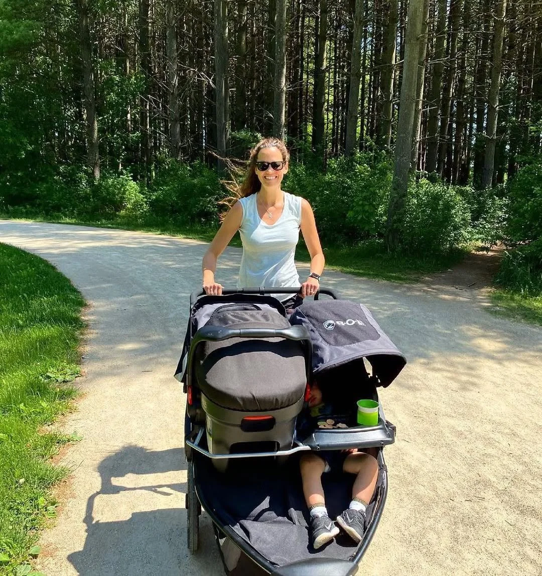 A family taking a walk outdoors with BOB stroller