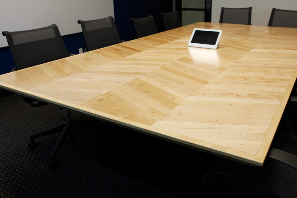  Custom conference table made with reclaimed/salvaged maple flooring recovered from project site demolition. 