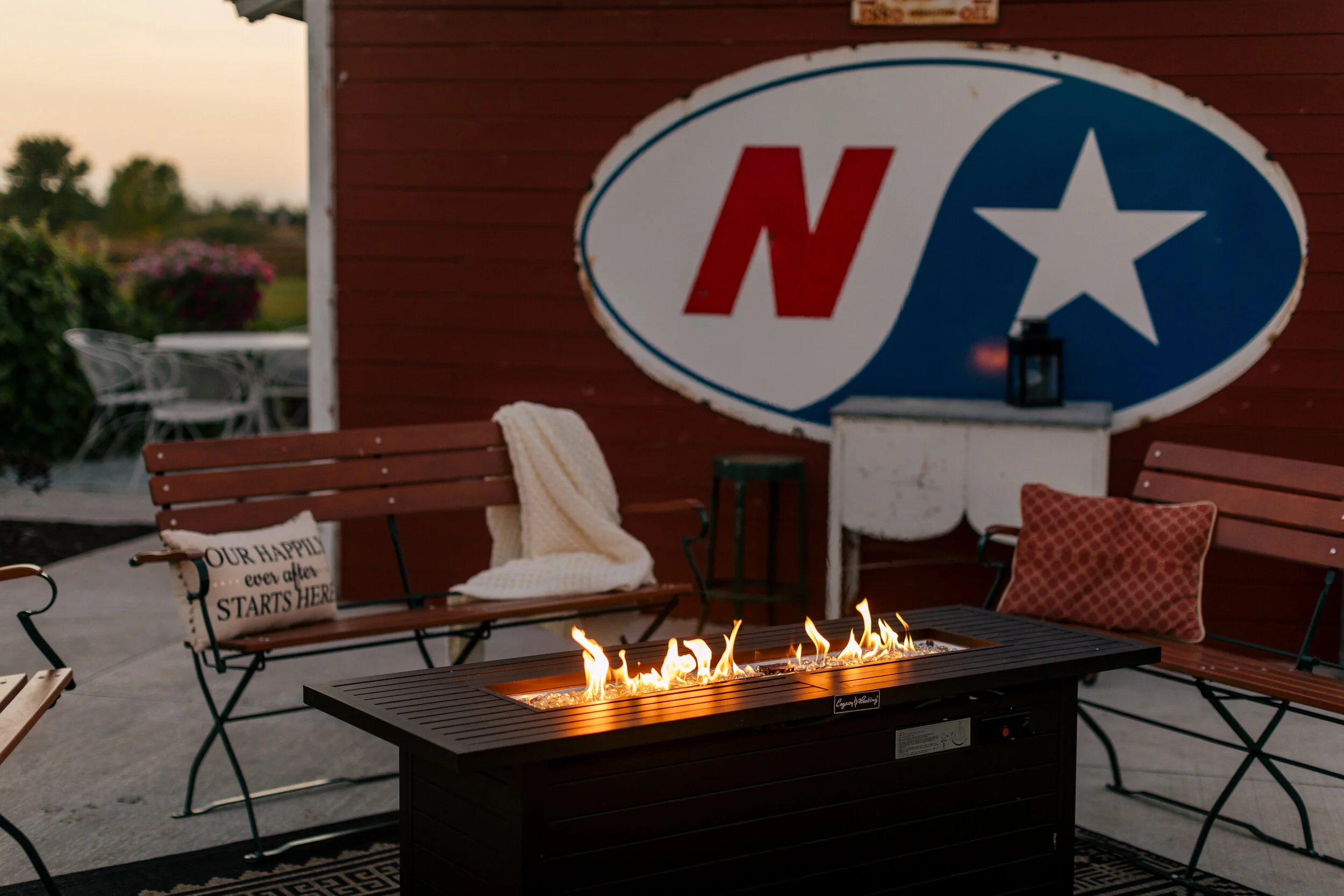 Outdoor wedding reception with dramatic evening lighting and illuminated gathering spaces