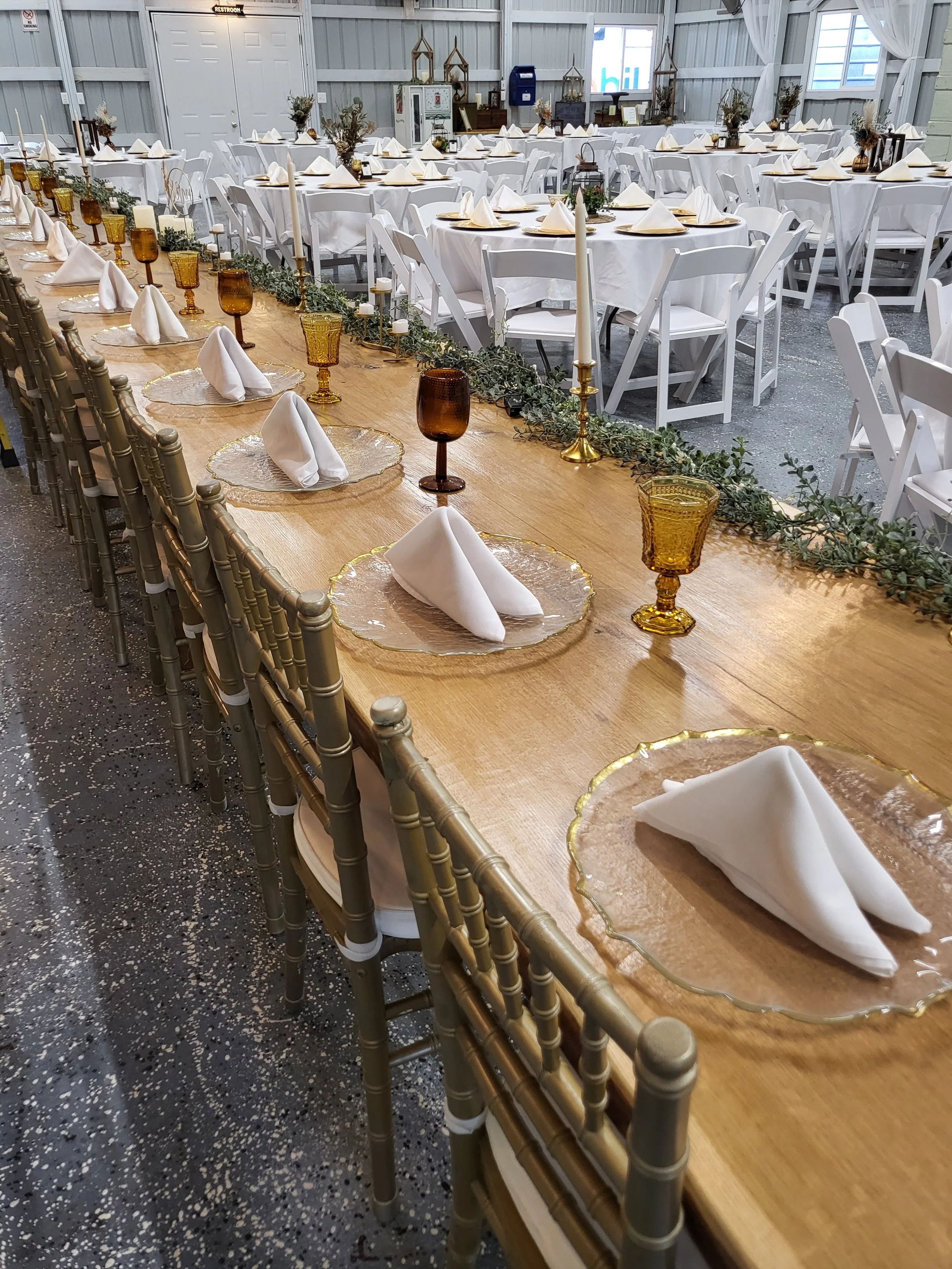 The 32ft long table at the Adler Ranch Banquet Hall with  tables set for wedding meal