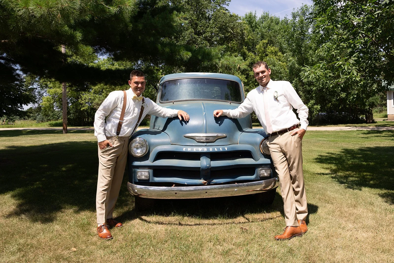 Groomsmen posing by little blue truck
