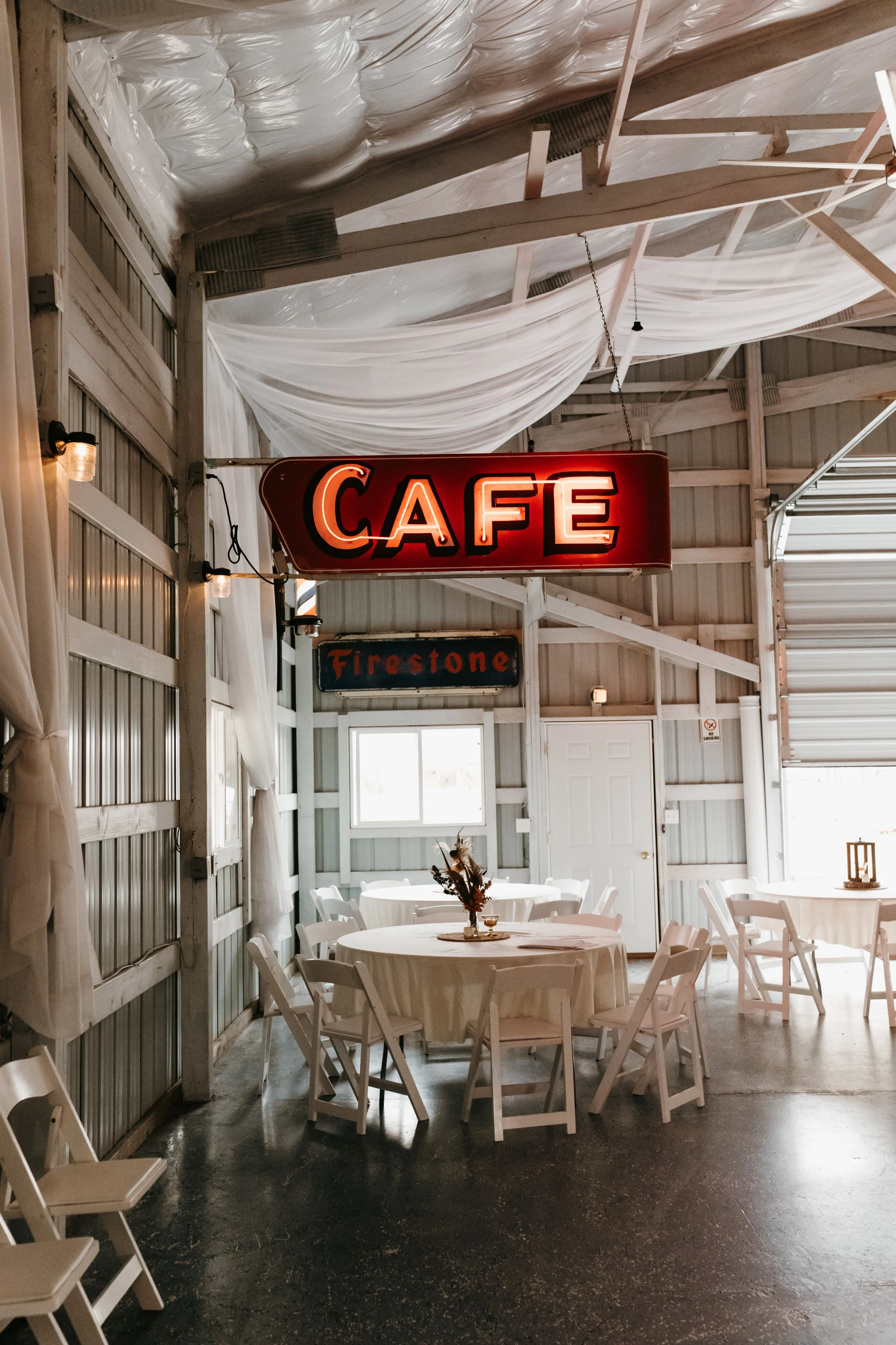 The inside of the Banquet Barn with it's Vintage CAFE sign and round tables and chairs at Adler Ranch Wedding Venue near Alexandria MN
