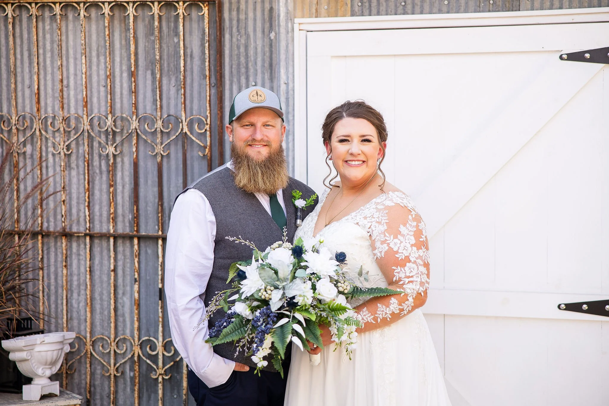 bride and groom portrait at Adler Ranch in front of antique grate and barn door on Grain Bin Bar during wedding reception timeline