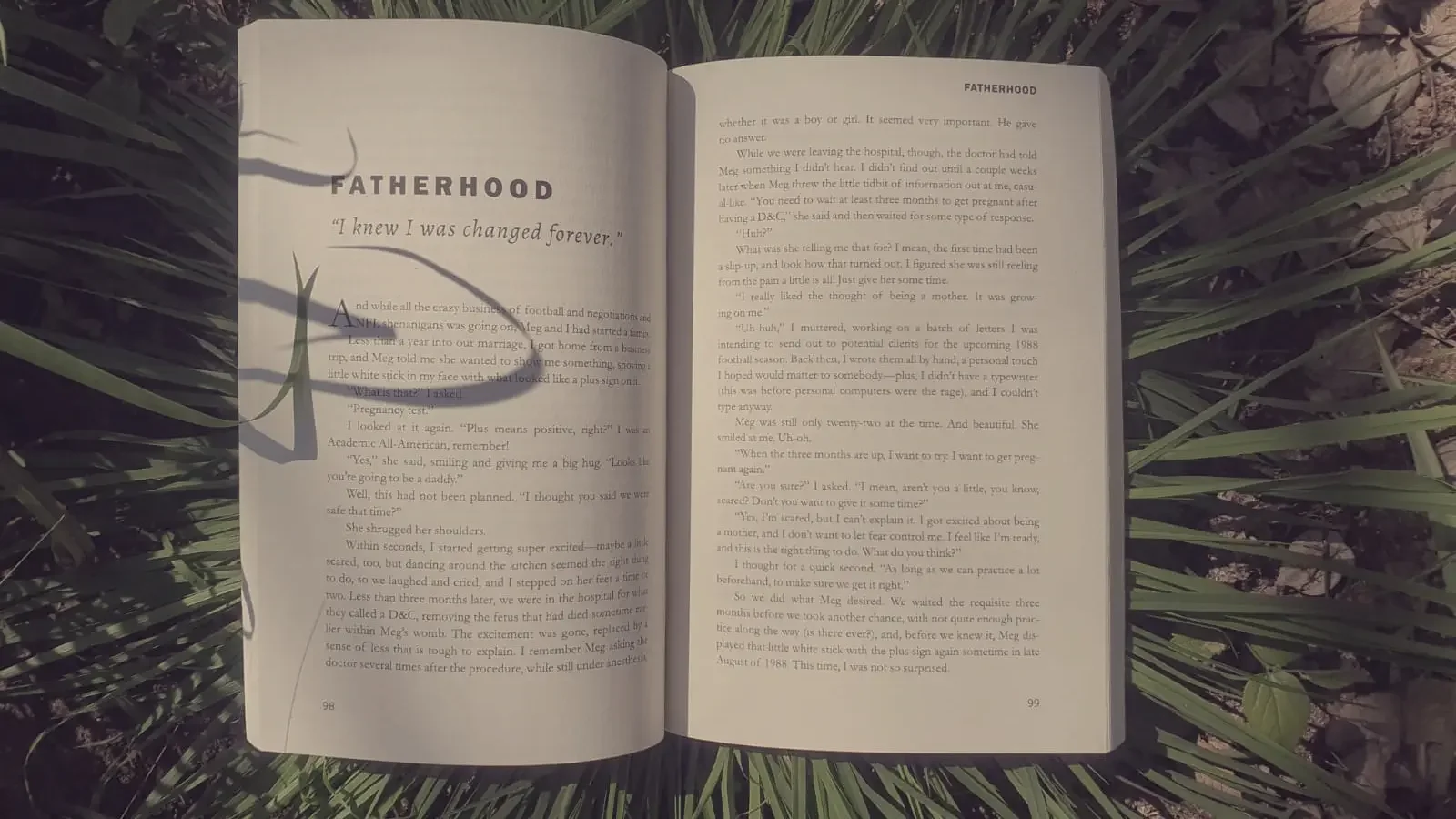 Phil Williams' memoir open to the Fatherhood chapter, resting on green grass