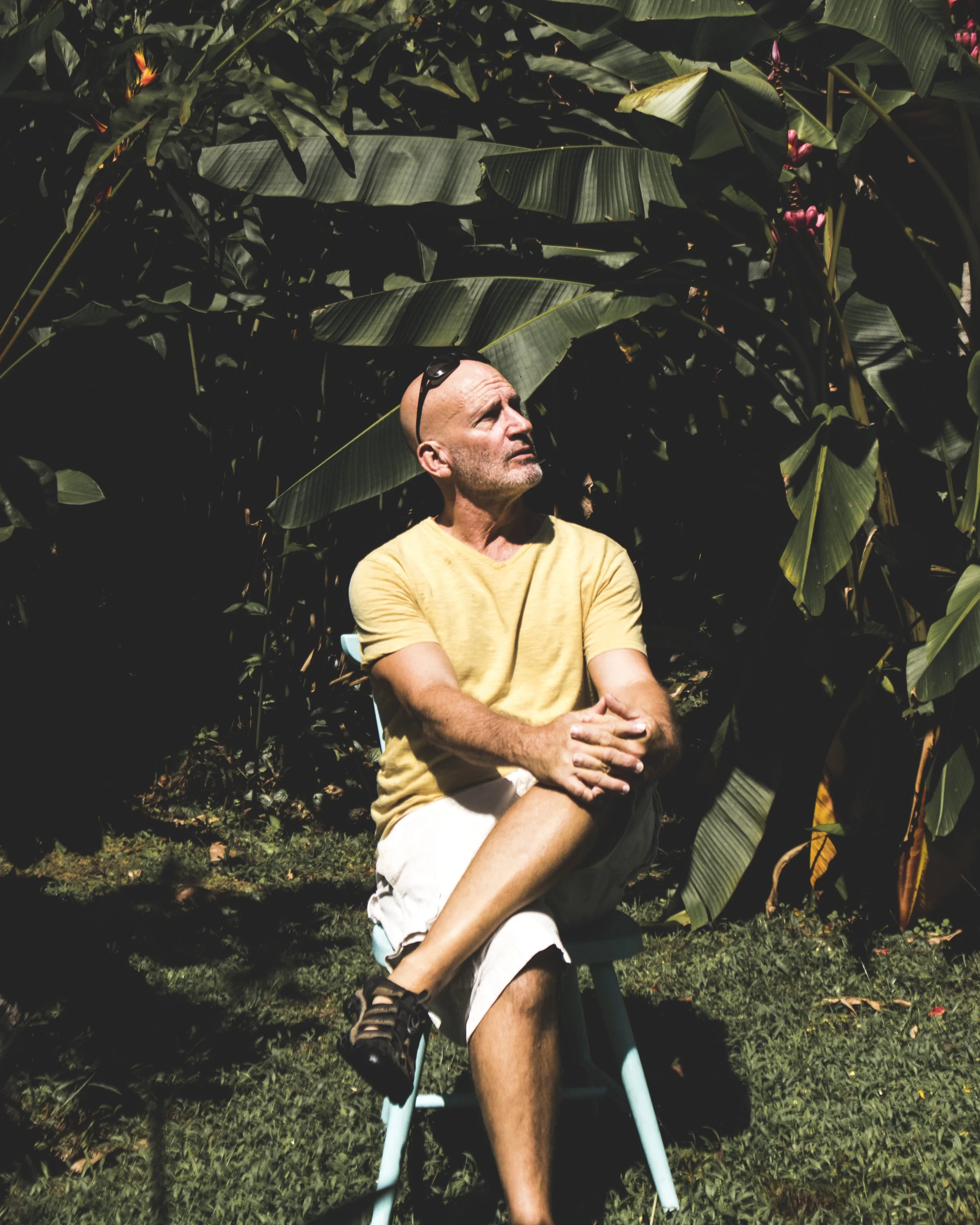 author, Phil Williams sitting on a stool in the jungle