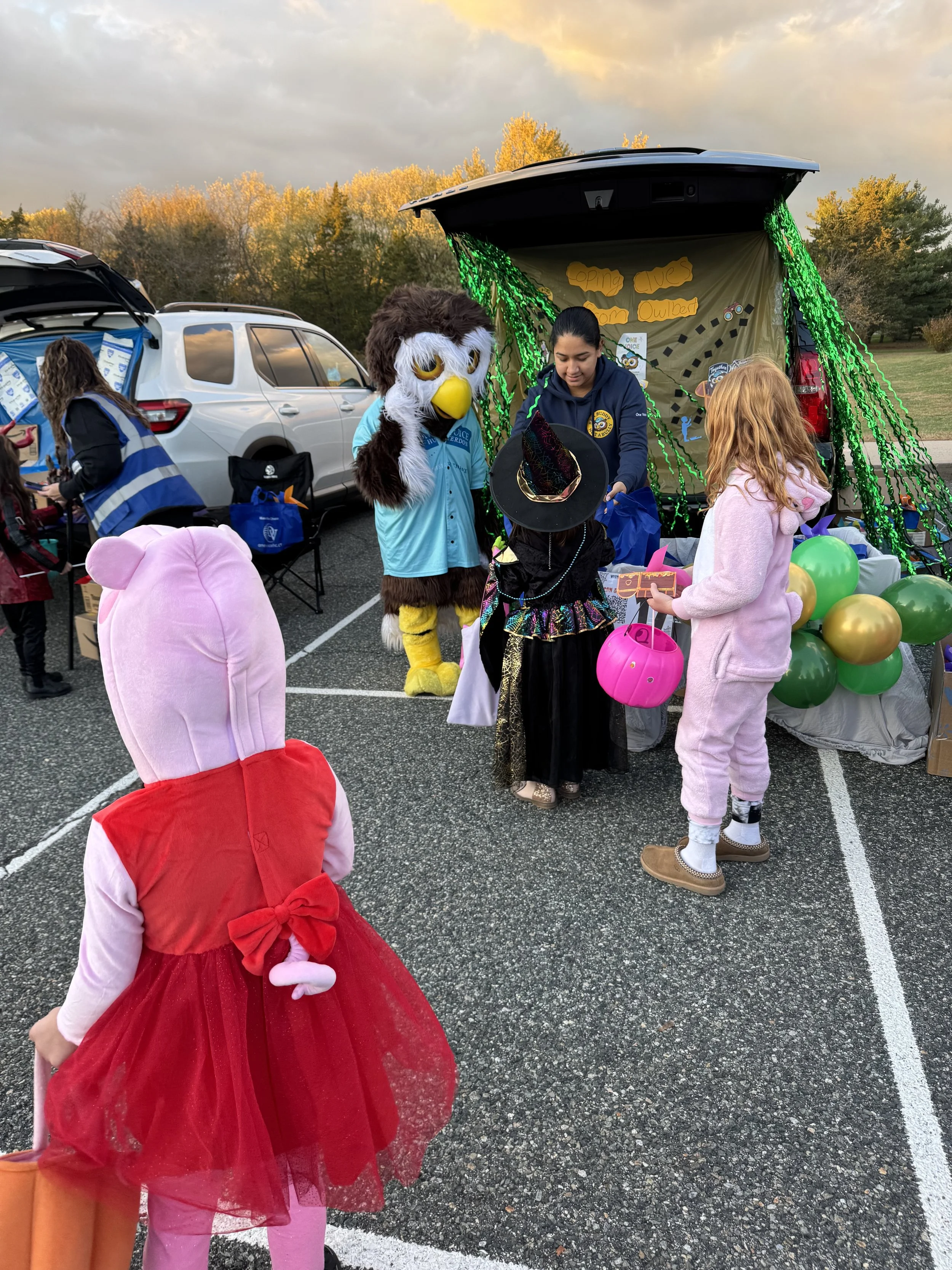 Amy giving kids bags with owlbert.jpeg