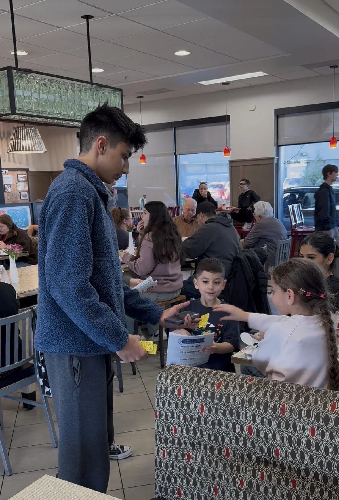 Manav giving out crayons and books to kids.jpg