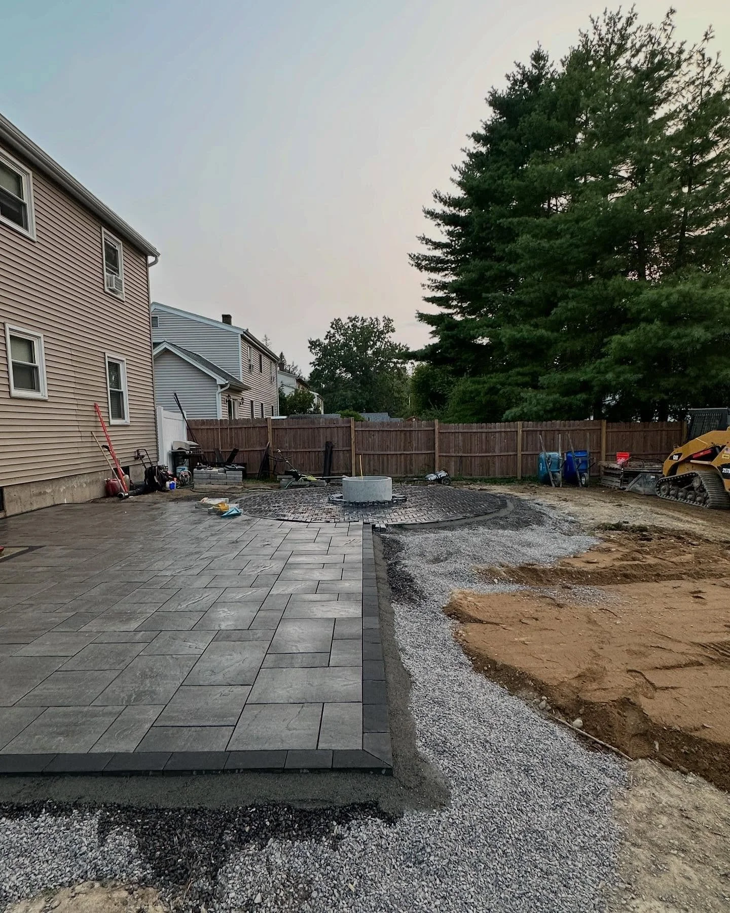 Halfway done photo - shows all the details of the build. The crushed stone layer, the concrete edging the @genestconcrete Windham ridge, boredered by @nicolockpaving raven brick, a showcase of @unilock pavers around a @stonefirecore insert! This was 