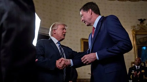 U.S. President Donald Trump shakes hands with then FBI director James Comey on Jan 22. Trump fired Comey on May 9. (Getty Images)