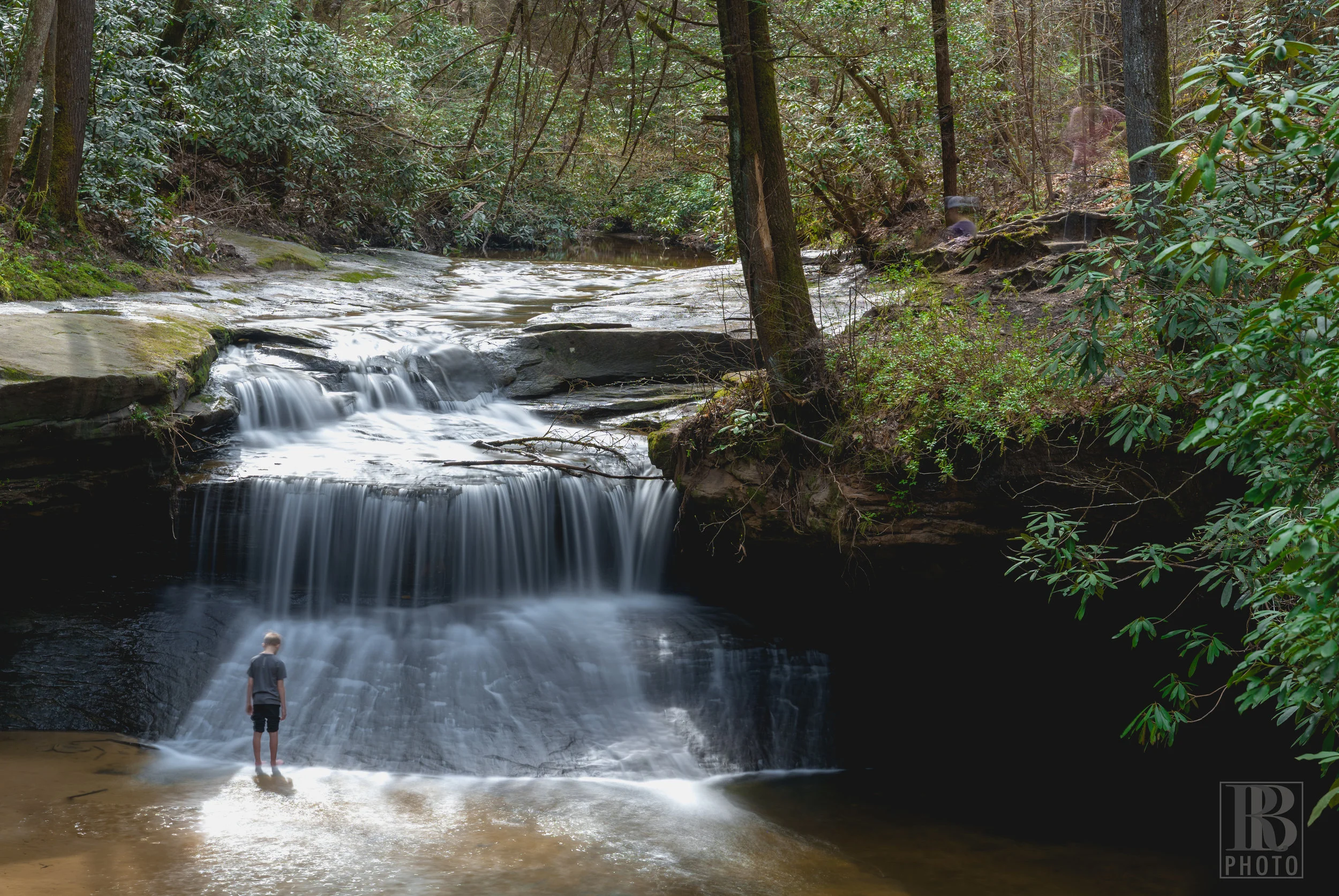In order to smooth out the waterfalls, I use a neutral density filter and a long exposure… 23 seconds in this case. The added benefit of doing that is that as people move in or out of the frame they generally don’t show up in the final image, or if they do it’s faint enough that they’re super easy to Photoshop out. This little dude stood stock-still for the entire 23 second exposure and actually turned out to provide a really cool element to the final image.